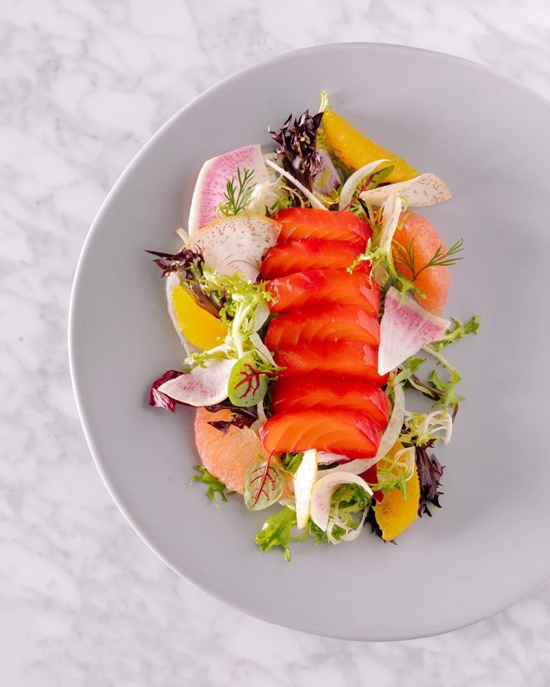 Meet the Juniper Gin Cured Steelhead ✨

Bright. Botanical. Balanced.

House-cured steelhead kissed with juniper gin, layered with shaved fennel + heirloom radish for that fresh crunch, preserved lemon for a pop of citrusy depth, and finished with a d