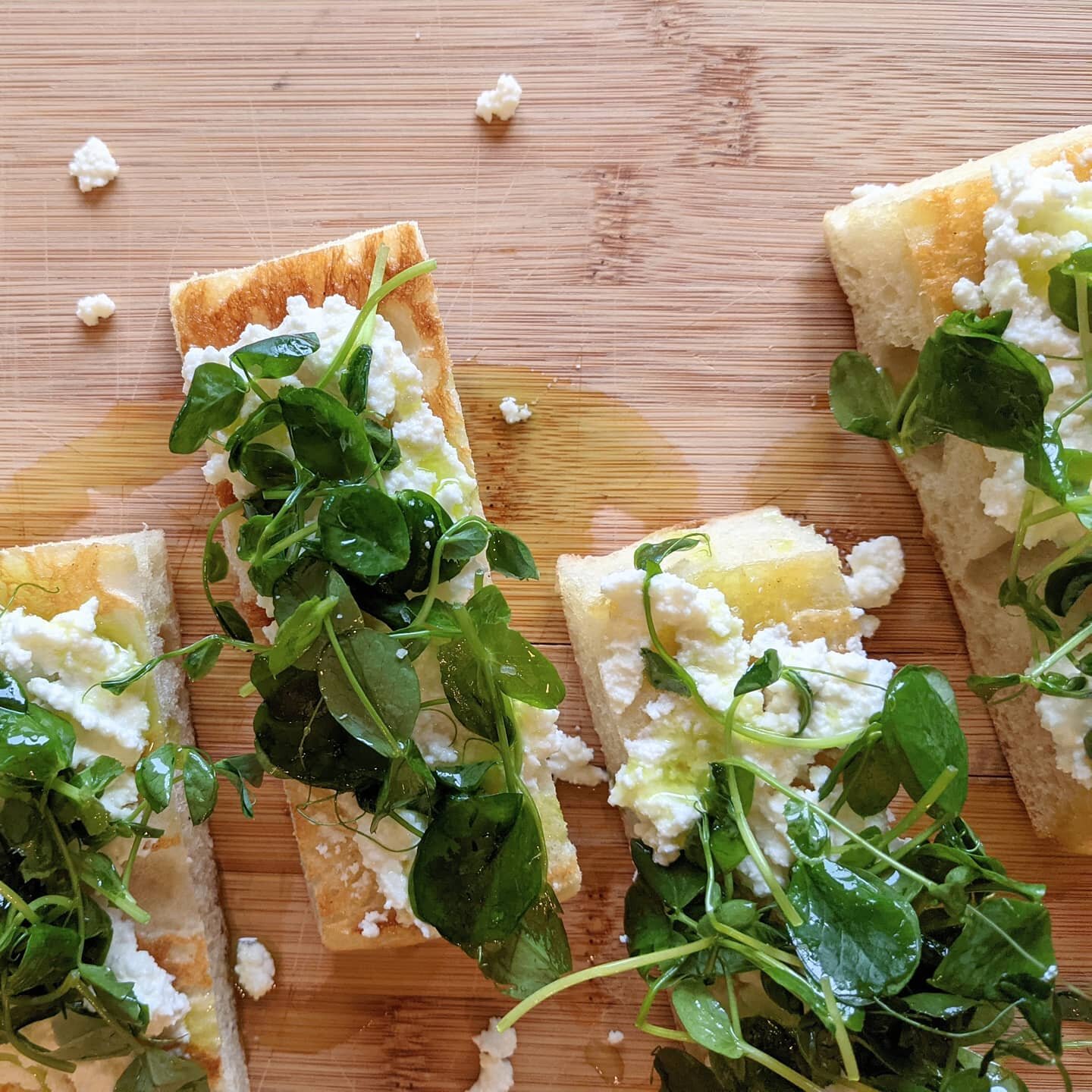 First course from last night's spring inspired dinner - ricotta crostini with pea shoots &amp; chive oil.
.
This was a quick easy starter. I made my own foccacia, but you could certainly buy a loaf to use. Toss the peashoots with a bit of chive oil. 