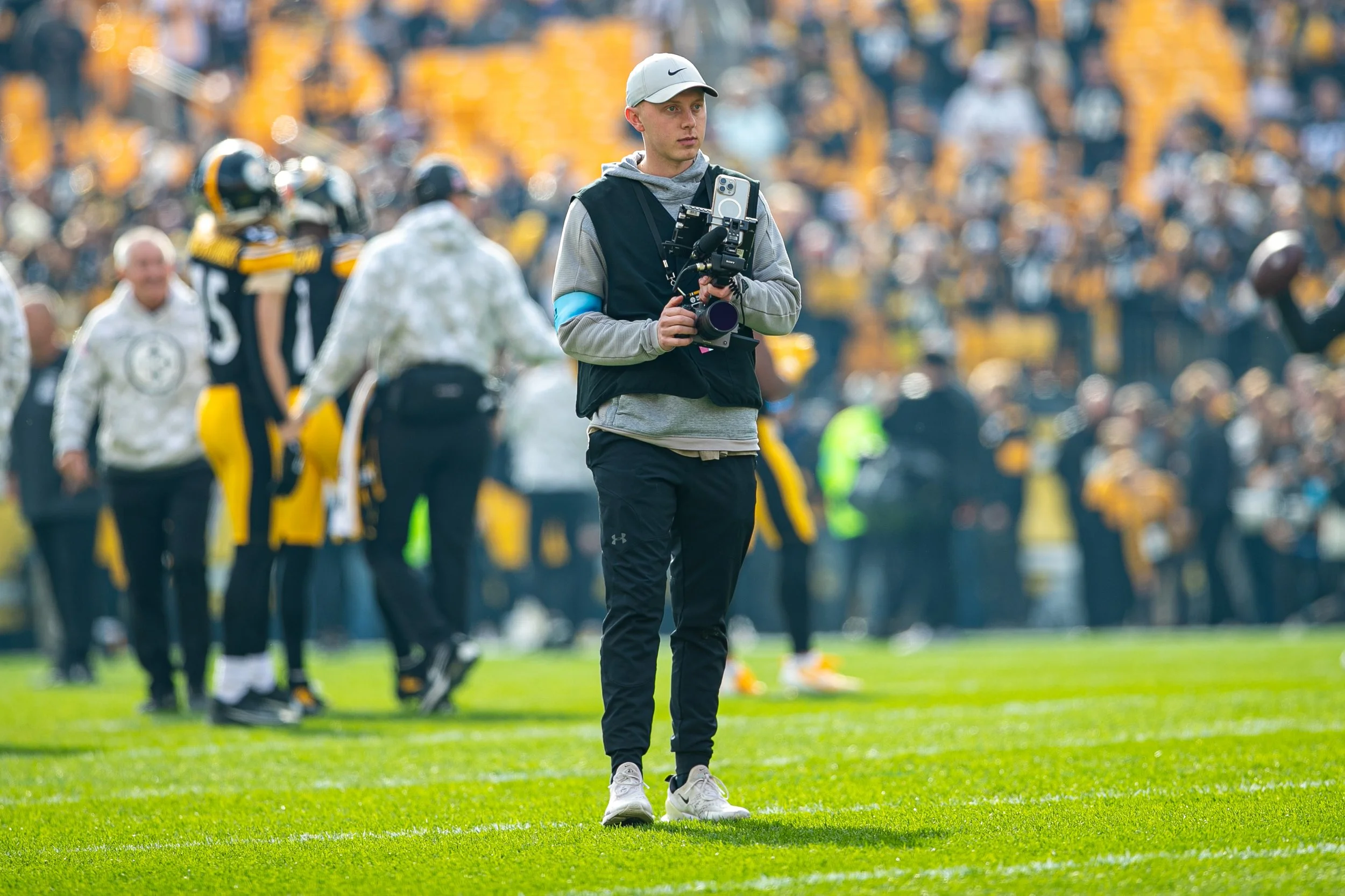 Josh Veon photographing on the sideline at a Pittsburgh Steelers NFL game