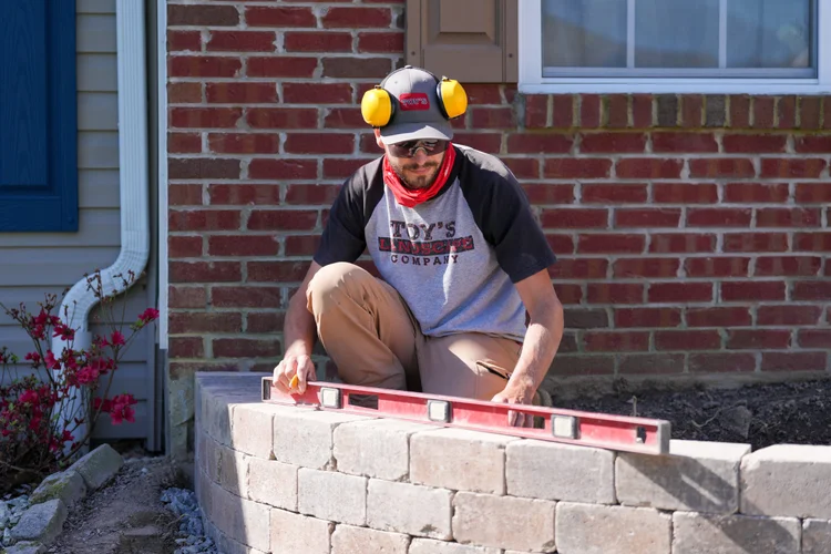 Toy's Landscape crew working on a retaining wall installation