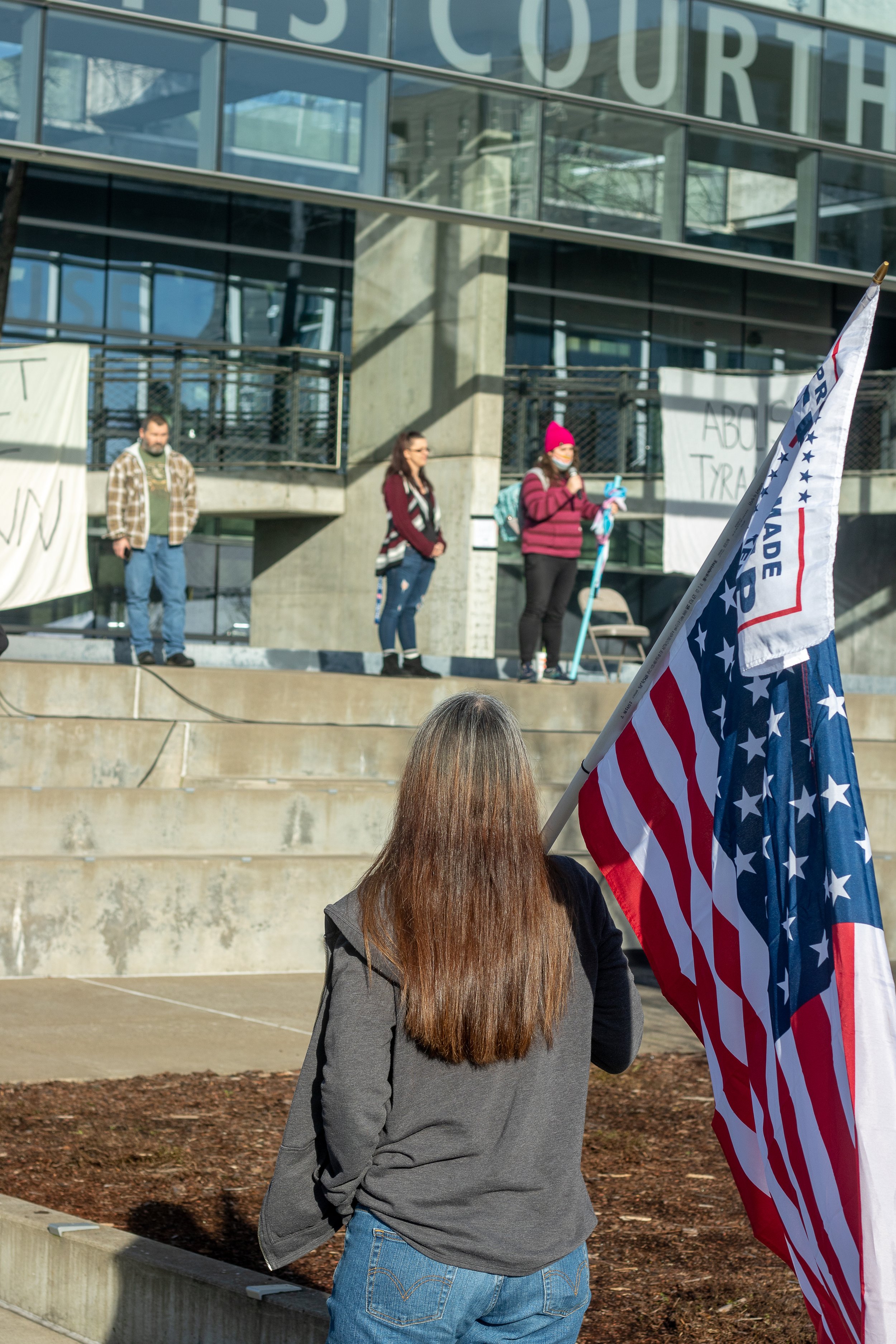 A woman listens to one of the many speakers that gave speeches during the protest. A pro-Trump rally was held at Wayne Morse United States Courthouse in Eugene, Ore., on Jan. 9, 2021, in response to the riot that took place at U.S. Capitol earlier in