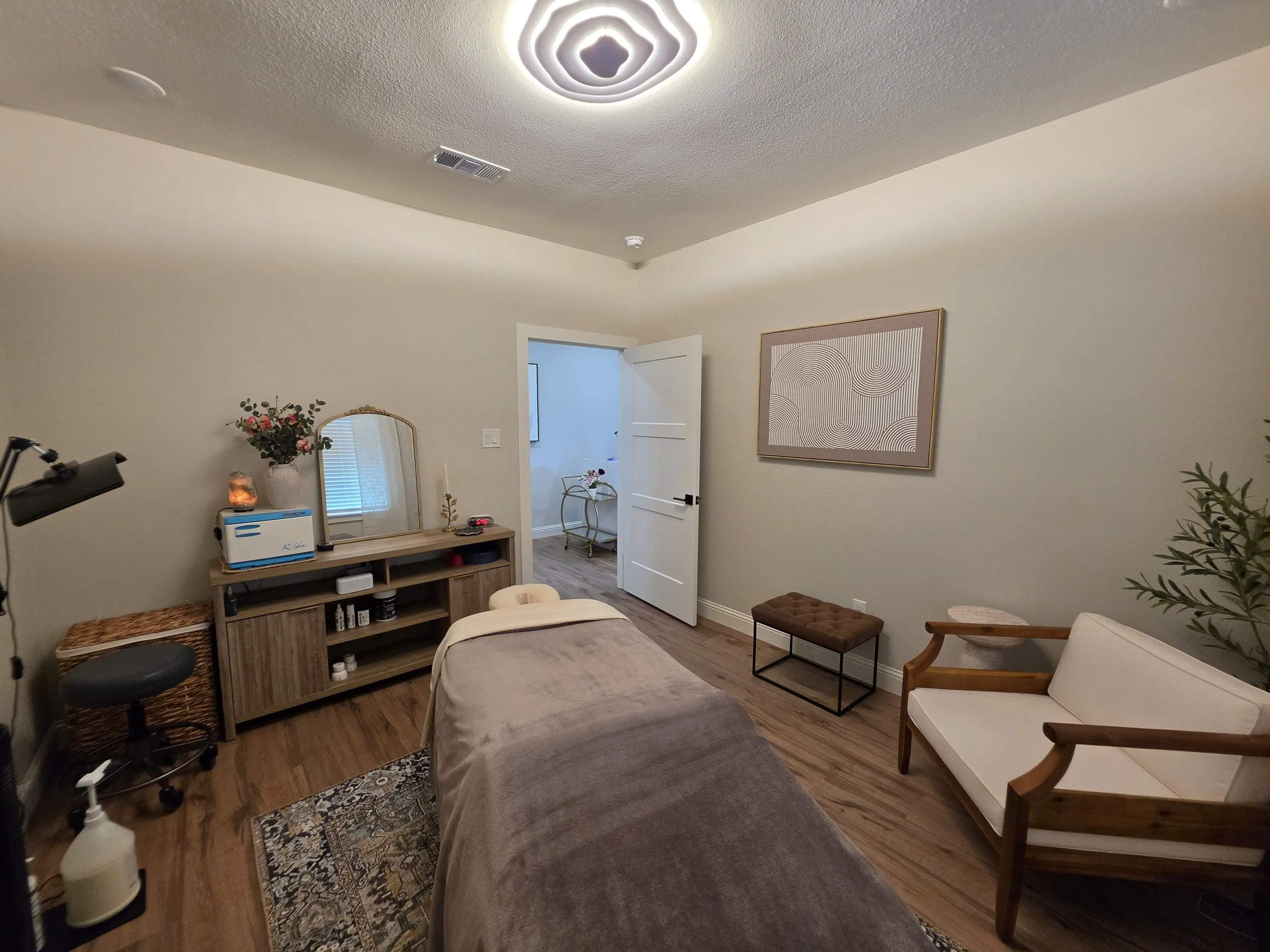 Relaxing, serene massage therapy space with modern lighting and brass vintage accent decor.