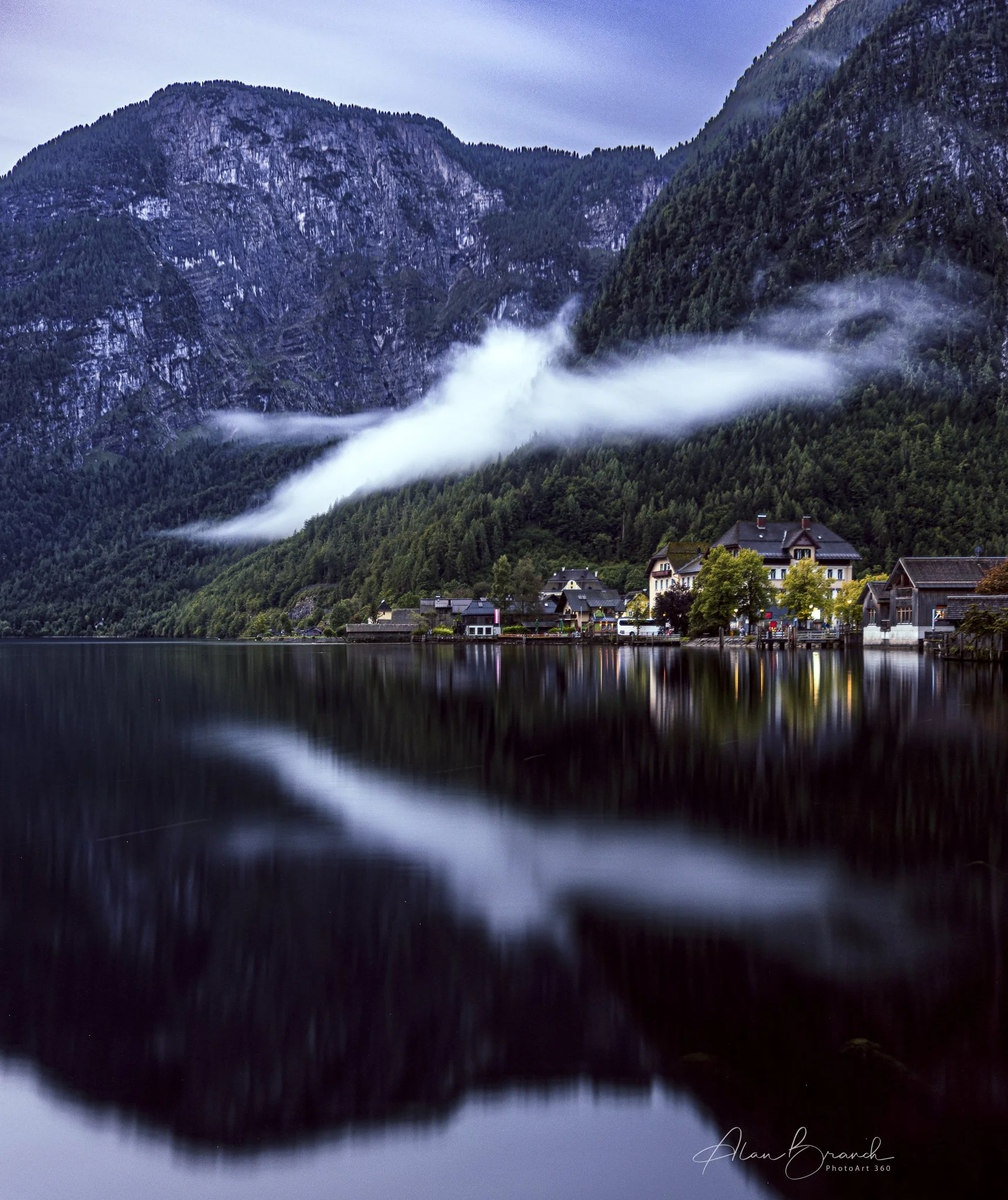 Hallstatt over the lake from the Northern side with a wisp of cloud typical of the early morning humidity which can disappear when hit by the sun