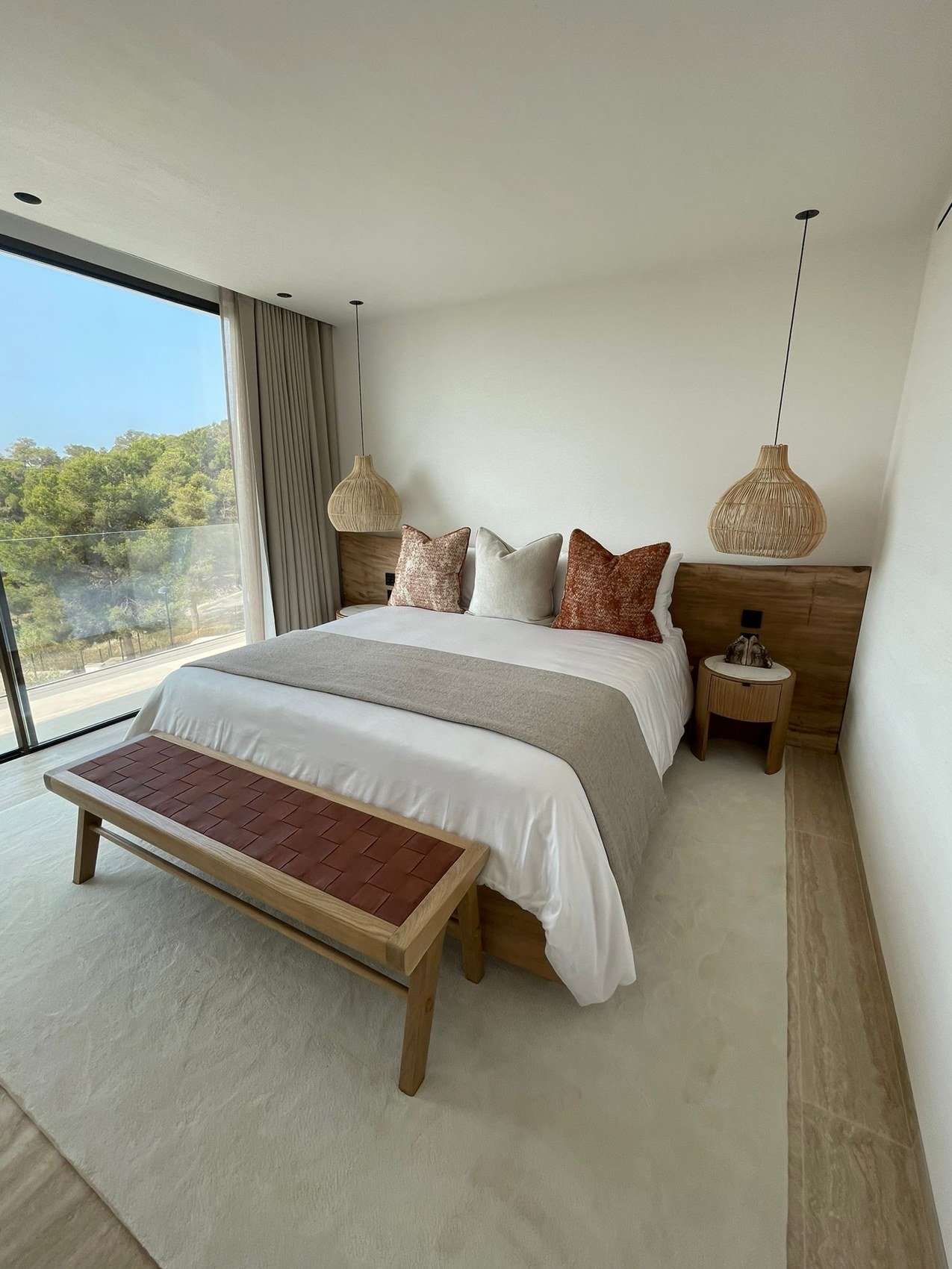 Bedroom 02 — Completed build
Natural textures and warm accents

The site photograph shows a similar combination of timber, woven lighting and warm textile accents. The two views capture the room from different angles and in different lighting conditi