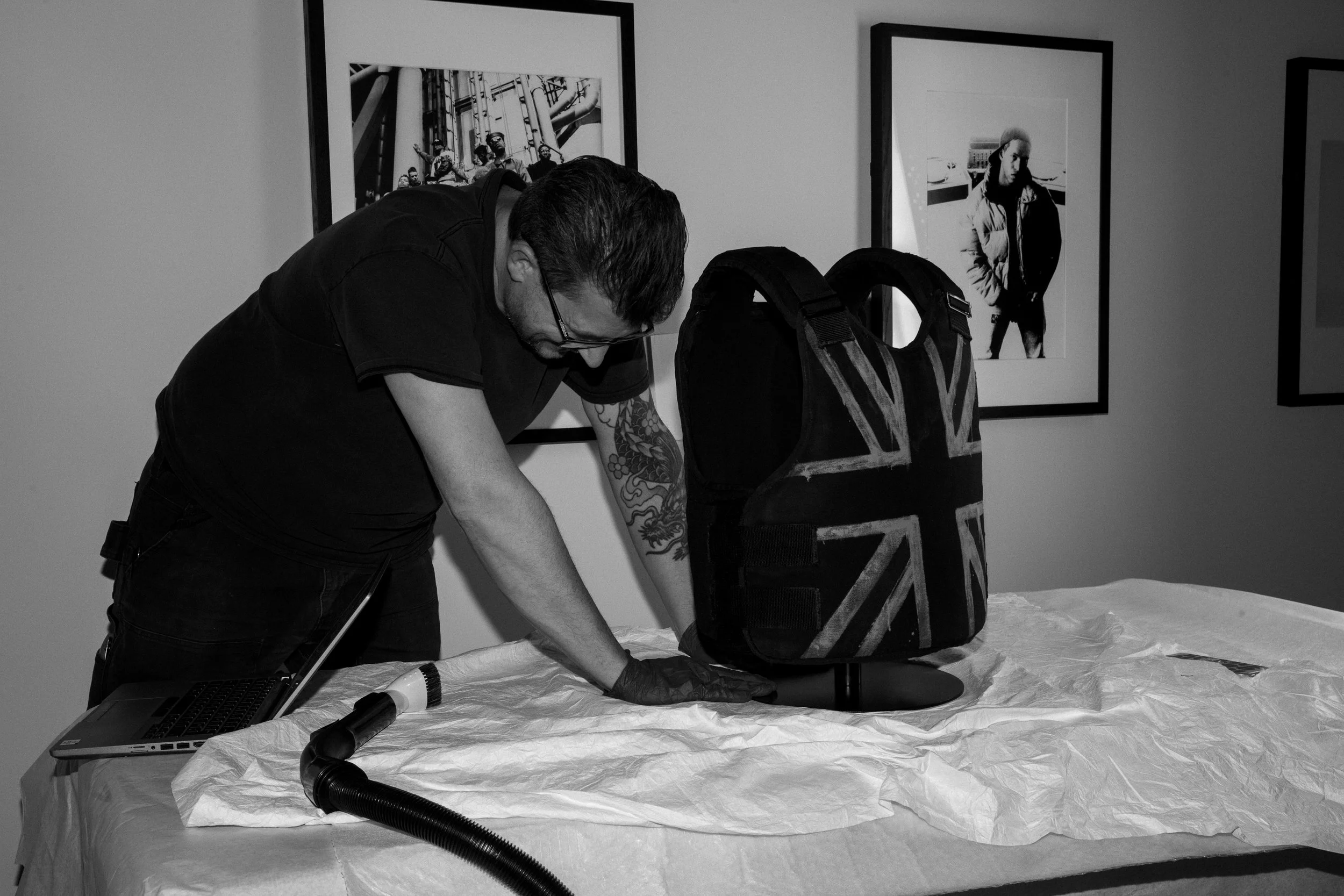 V&A East Museum team prepares Stormzy’s 2019 Glastonbury vest, designed by Banksy. Inside V&A East Museum’s inaugural exhibition, The Music is Black_ A British Story. © Adama Jalloh for the V&A.jpg