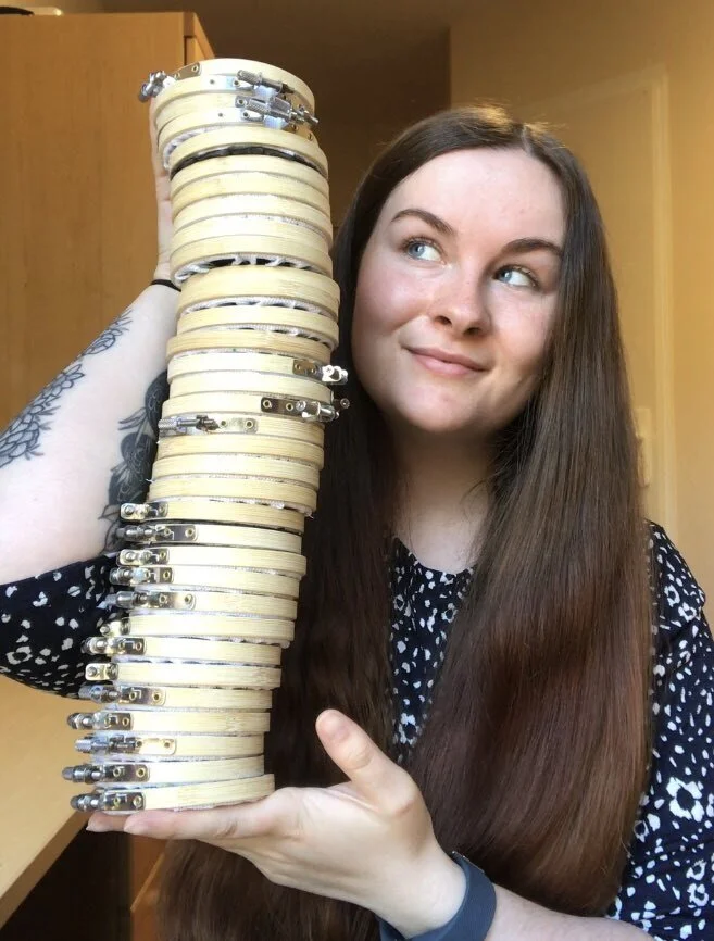  Me holding a large stack of embroidery hoops. In my spare time, I enjoy cross stitching and embroidery. I run a small online business selling cross stitch patterns and completed hoops on Etsy called Stitching Science. 
