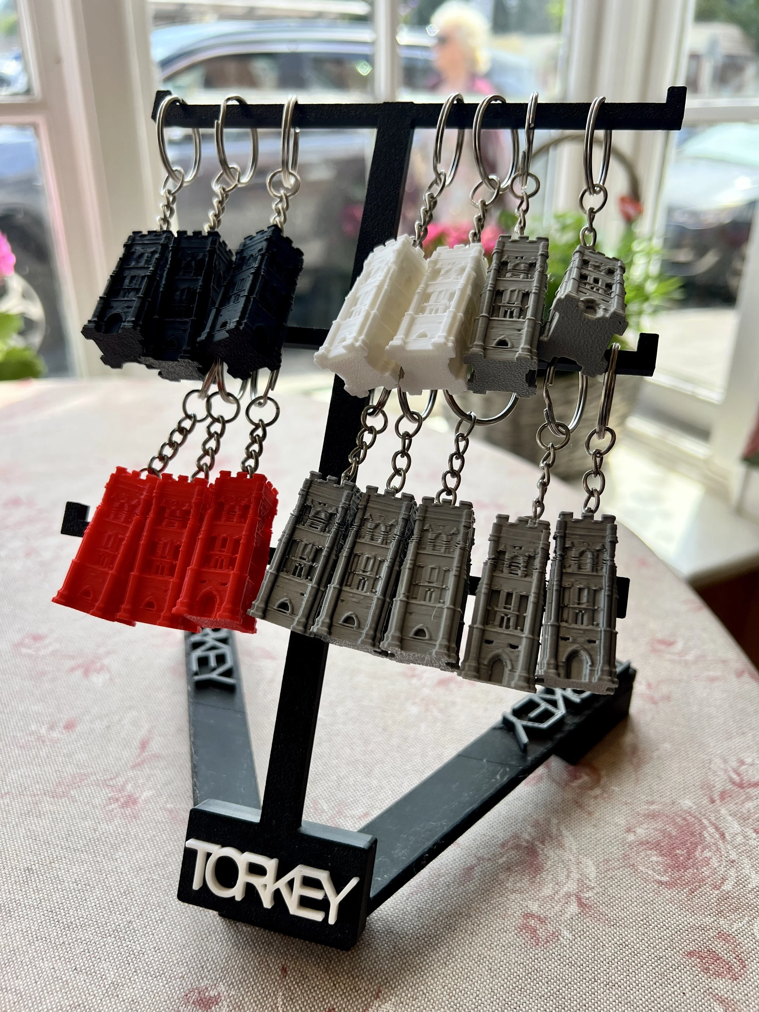 A display stand with miniature 3D-printed buildings representing Turkey, arranged in a row with black, white, gray, and red buildings.
