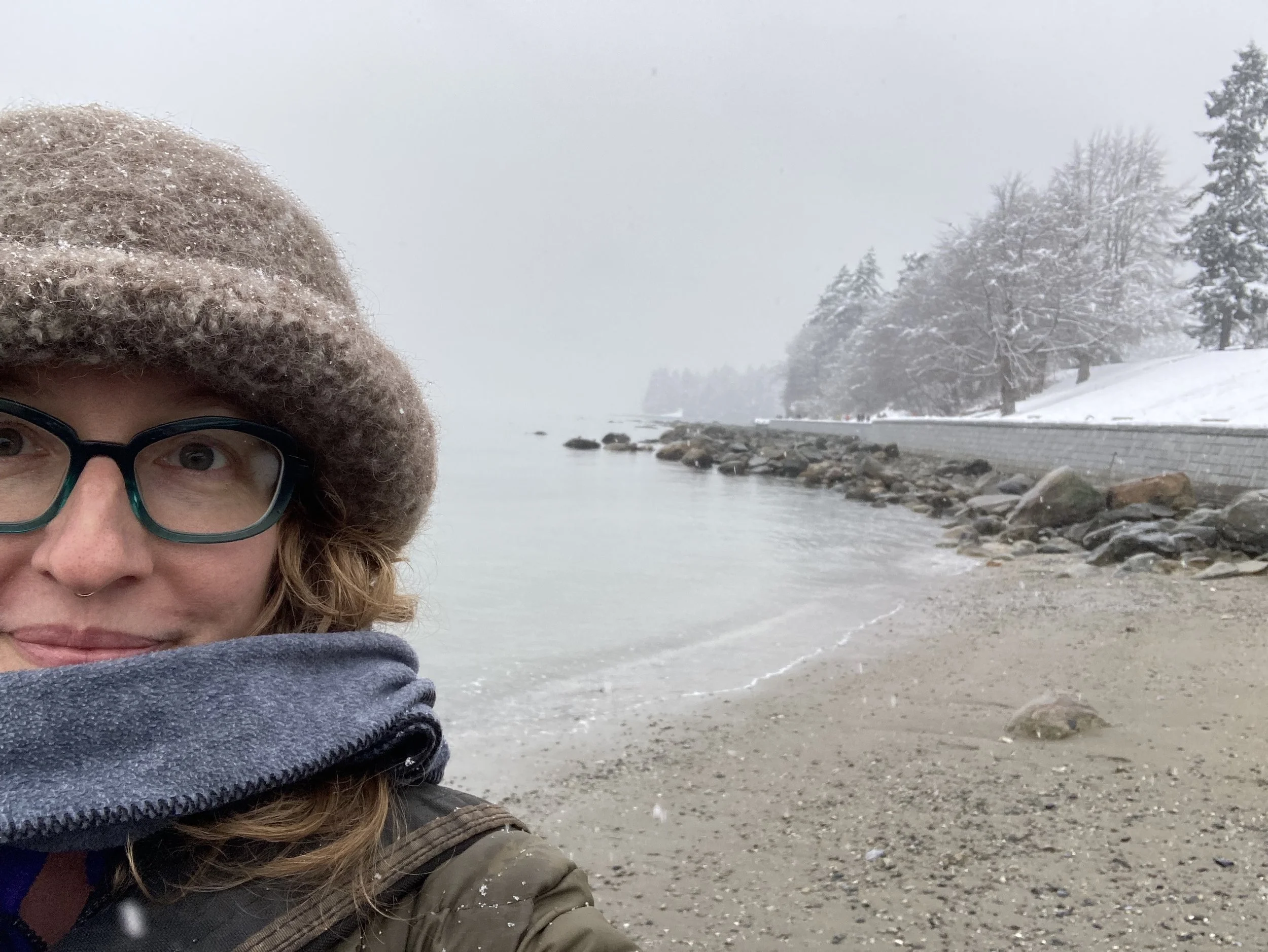 Selfie of Meghan in winter layers with the snowy sea behind her.