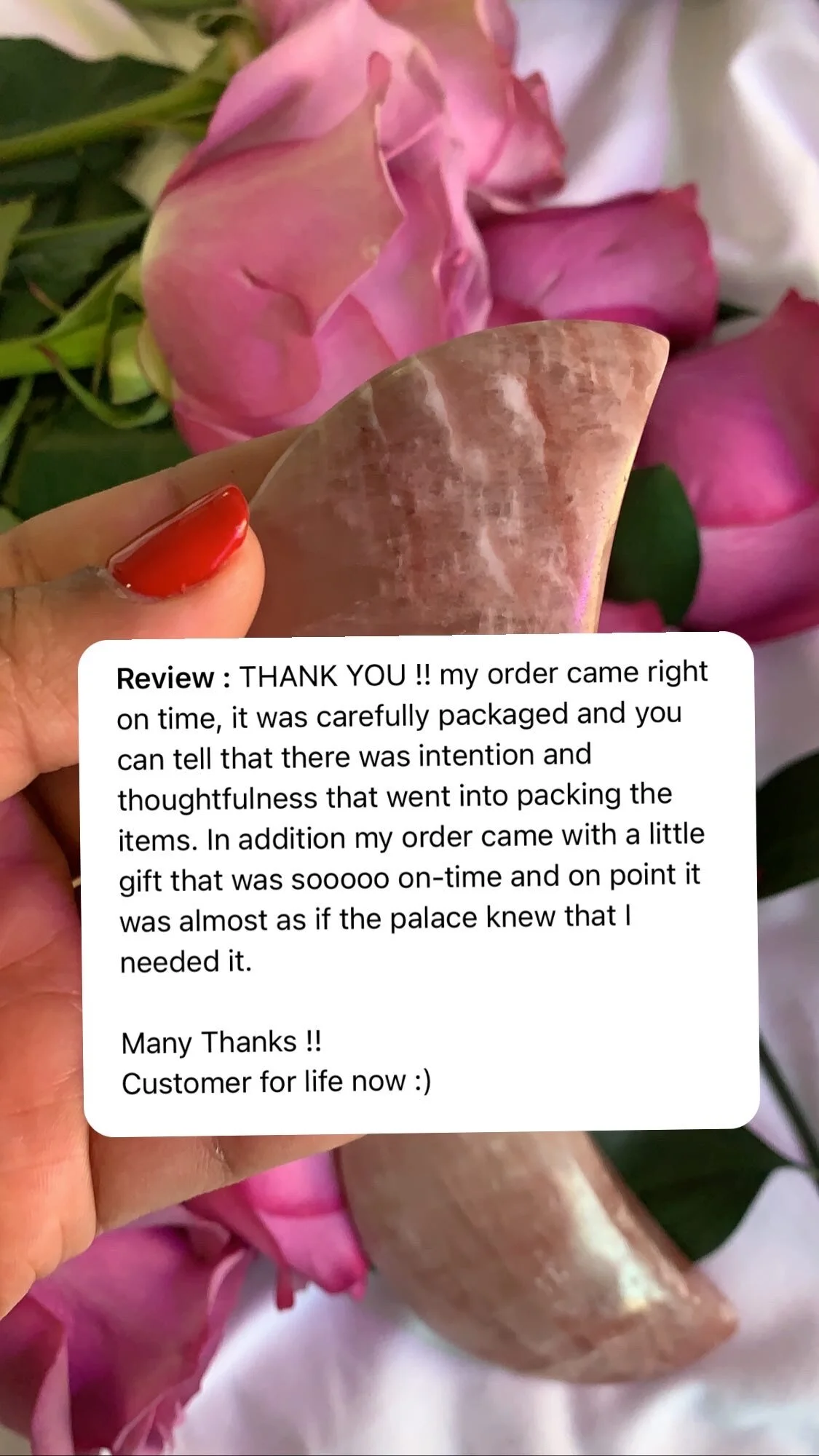A hand with red painted nails holding a transparent plastic sheet in front of pink roses. There is a customer review message superimposed on the image.