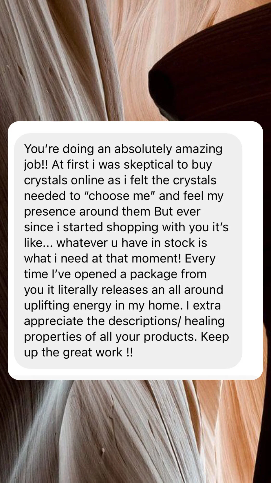 A text message over a background of natural wood patterns, expressing appreciation for someone's product dealing with crystals and energy.