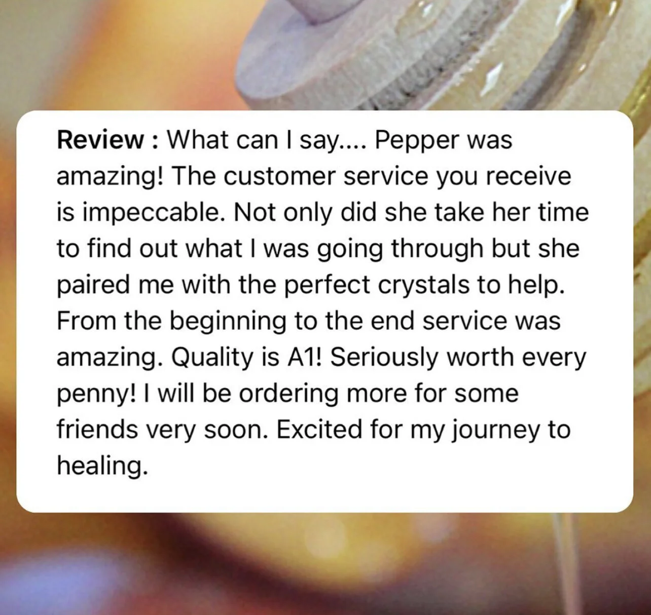 Close-up of a review text about a product, mentioning excellent customer service and quality, with a background featuring a crystal or mineral.