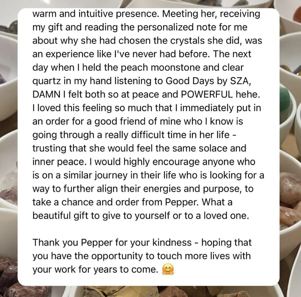 Screenshot of a note or message about the emotional experience of receiving a gift, listening to music, and sharing kindness with a friend, with a background of various bowls containing crystals and gemstones.
