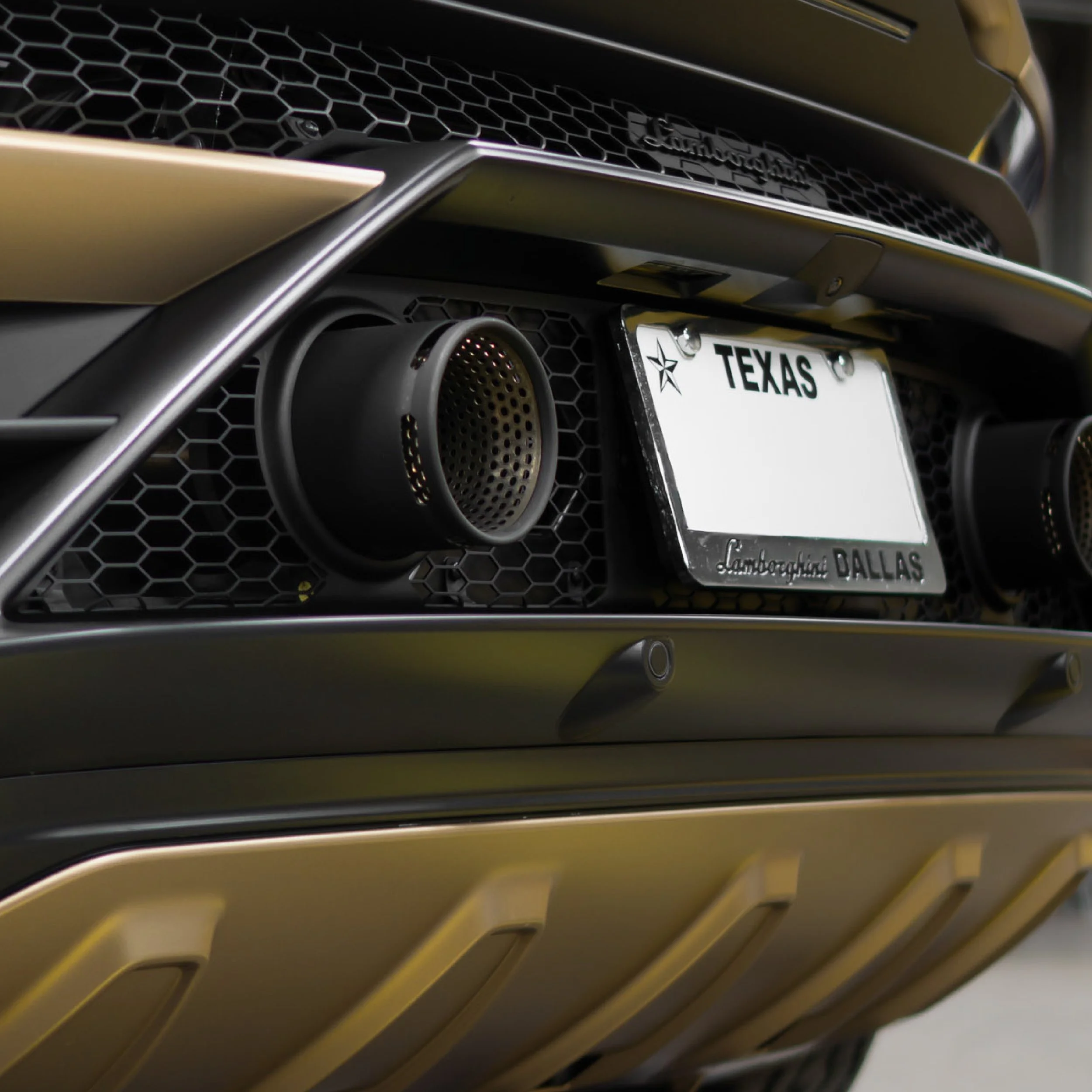 Close-up of a satin gold-wrapped SUV's front bumper, mesh grille, and fog light detail - EIGHTYNINE VWS custom vehicle wrap craftsmanship in Little Elm, TX
