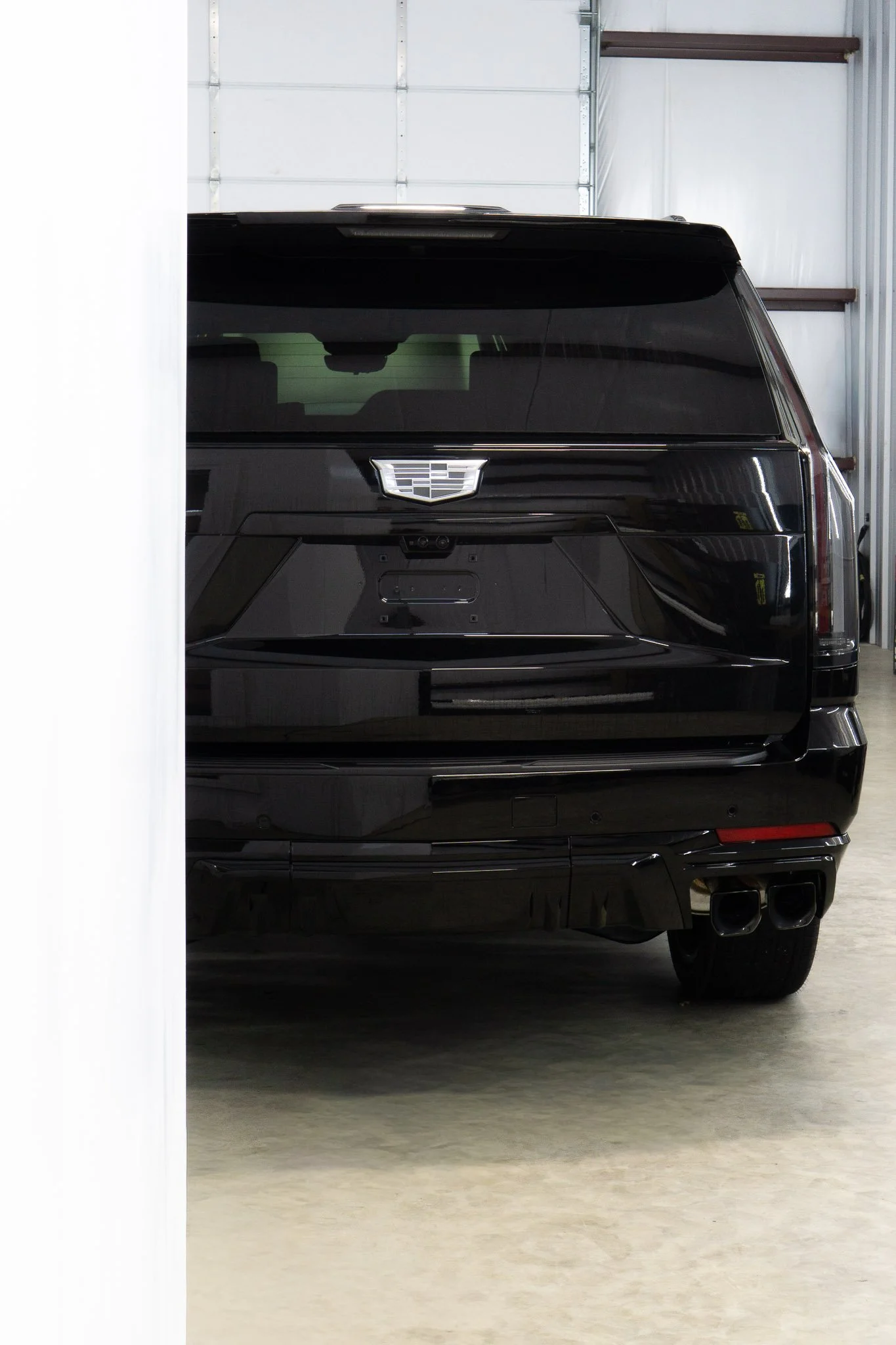 Rear view of a black Cadillac Escalade with paint protection film applied, parked in the EIGHTYNINE VWS studio in Little Elm, TX