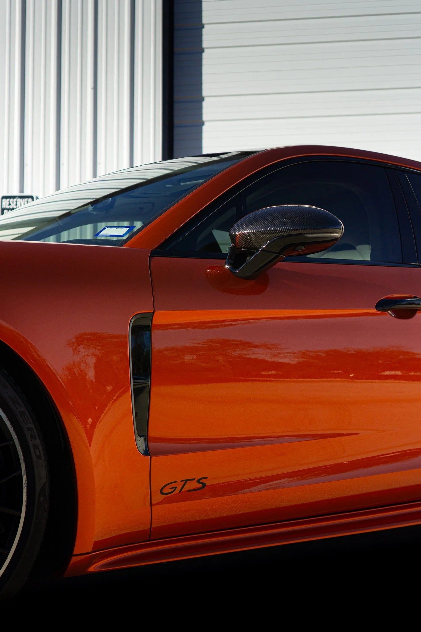 Side profile of an orange Porsche 718 Cayman with color change paint protection film, parked outside EIGHTYNINE VWS's studio in Little Elm, TX