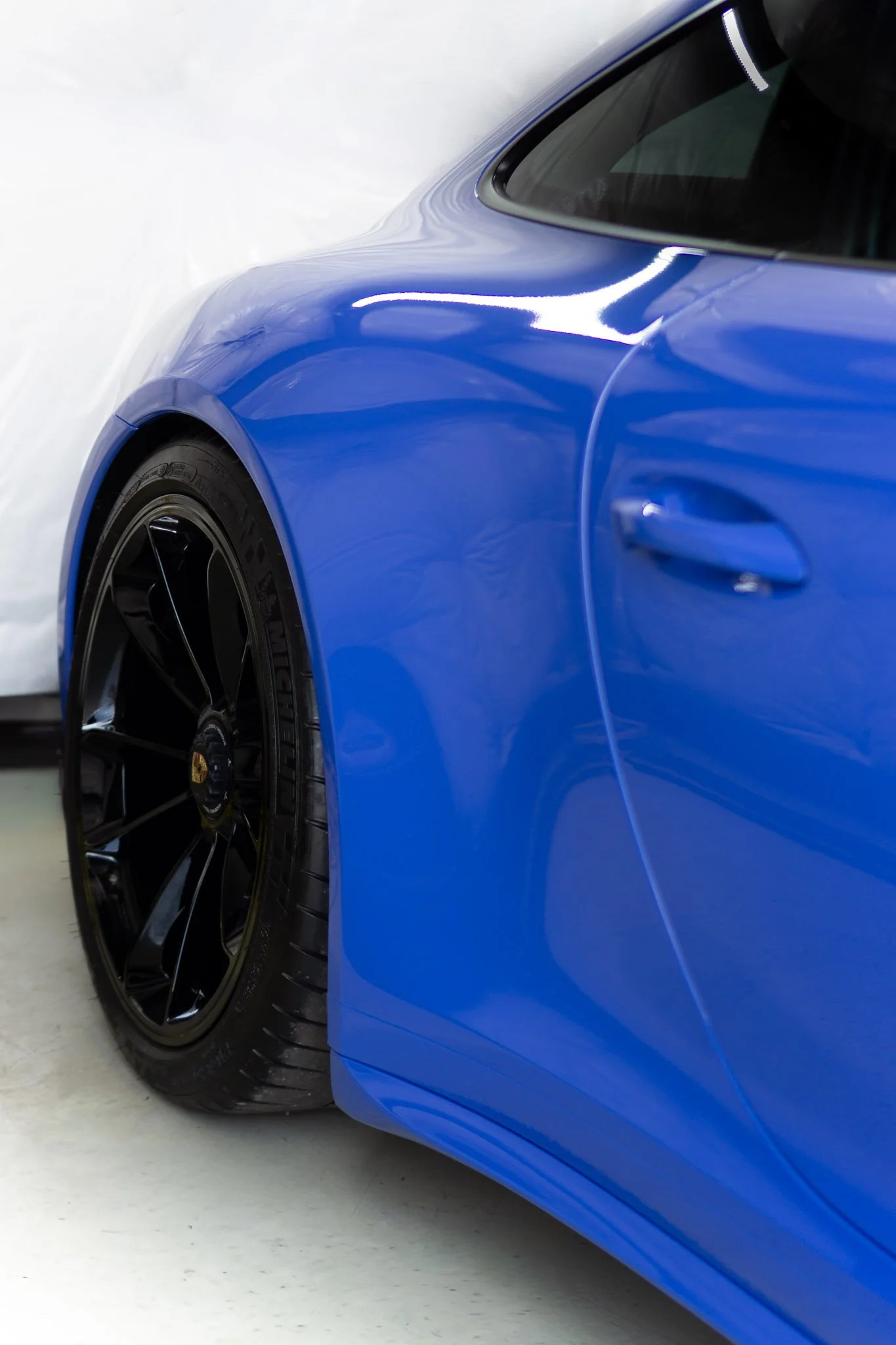 Rear wheel and fender of a blue Porsche 911 finished with paint protection film - PPF installation by EIGHTYNINE VWS in Little Elm, TX