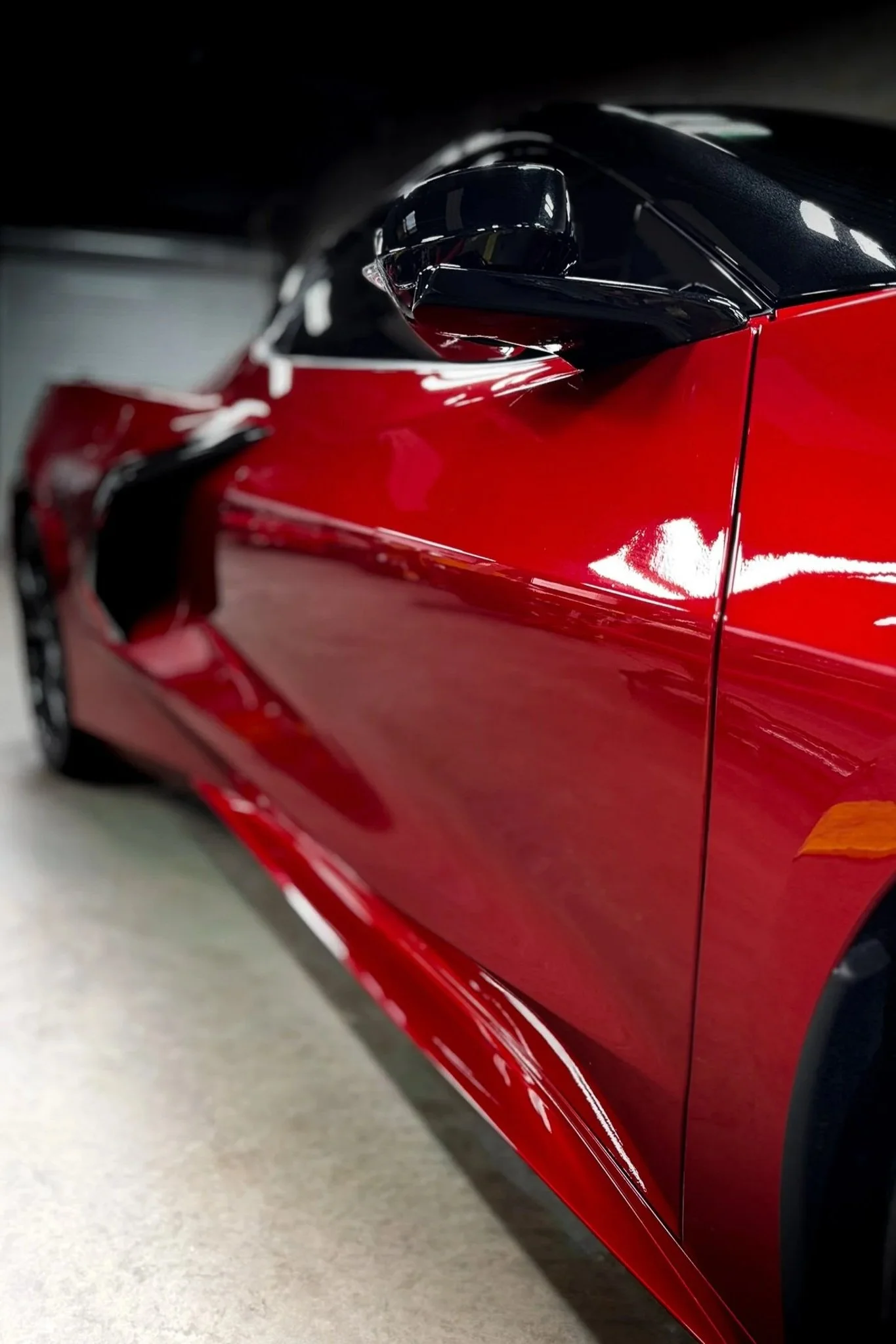 Side profile of a red sports car with paint protection film covering the front fender and door - EIGHTYNINE VWS PPF service in Little Elm, TX