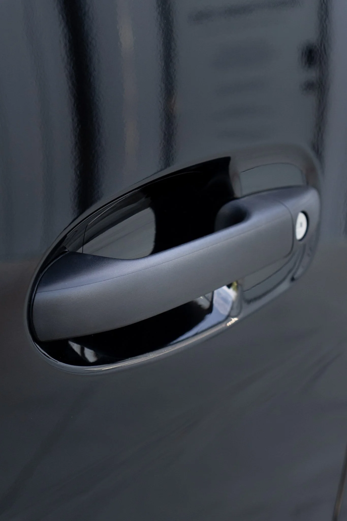 Close-up of a silver vehicle's door handle with paint protection film installed for chip and scratch resistance - EIGHTYNINE VWS PPF service in Little Elm, TX