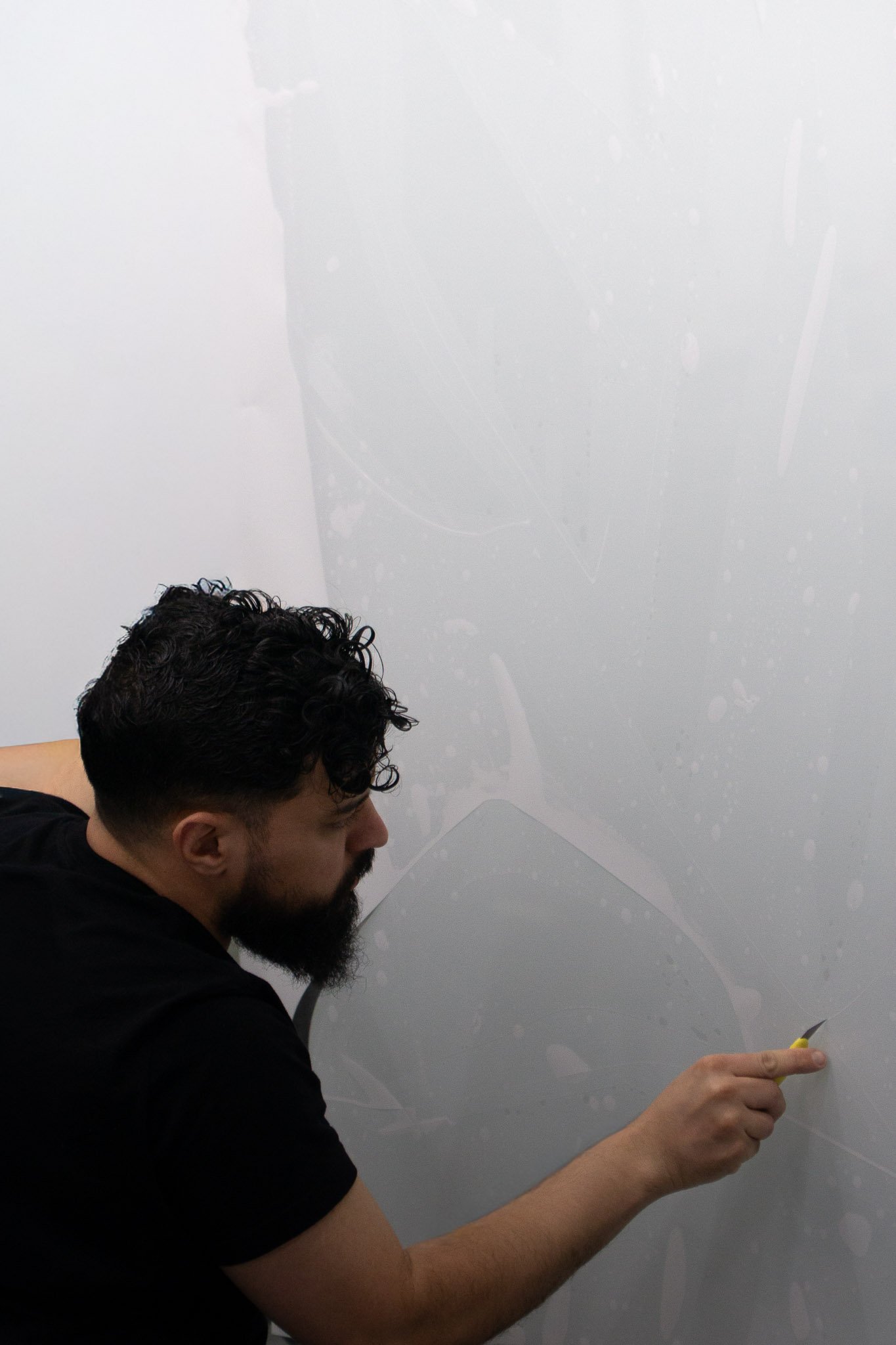 EIGHTYNINE VWS technician smoothing a large paint protection film panel during installation on a vehicle panel in Little Elm, TX