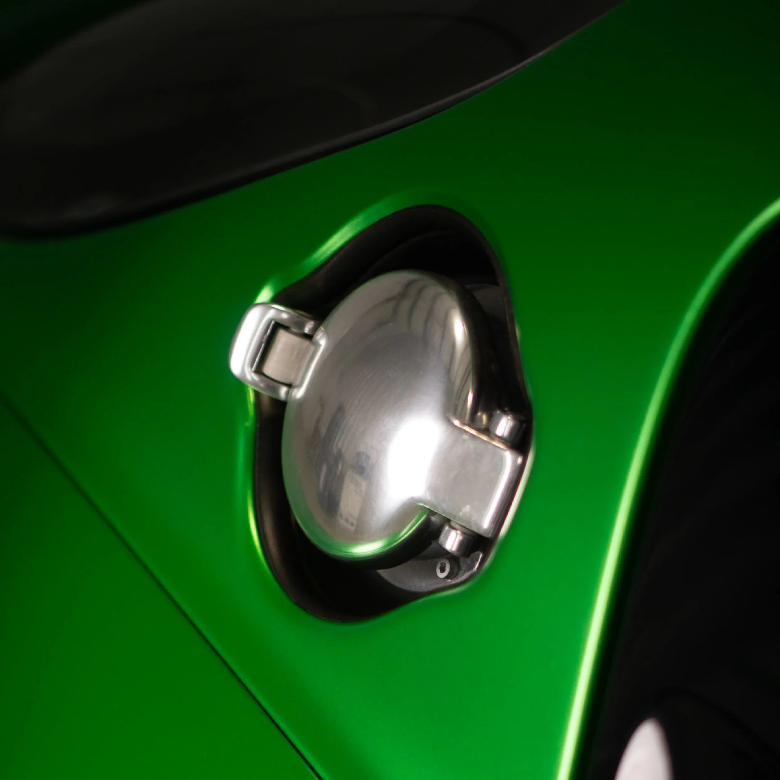 Close-up of the fuel cap and rear quarter panel on a vehicle wrapped in glossy emerald green vinyl - EIGHTYNINE VWS vehicle wrap detail in Little Elm, TX