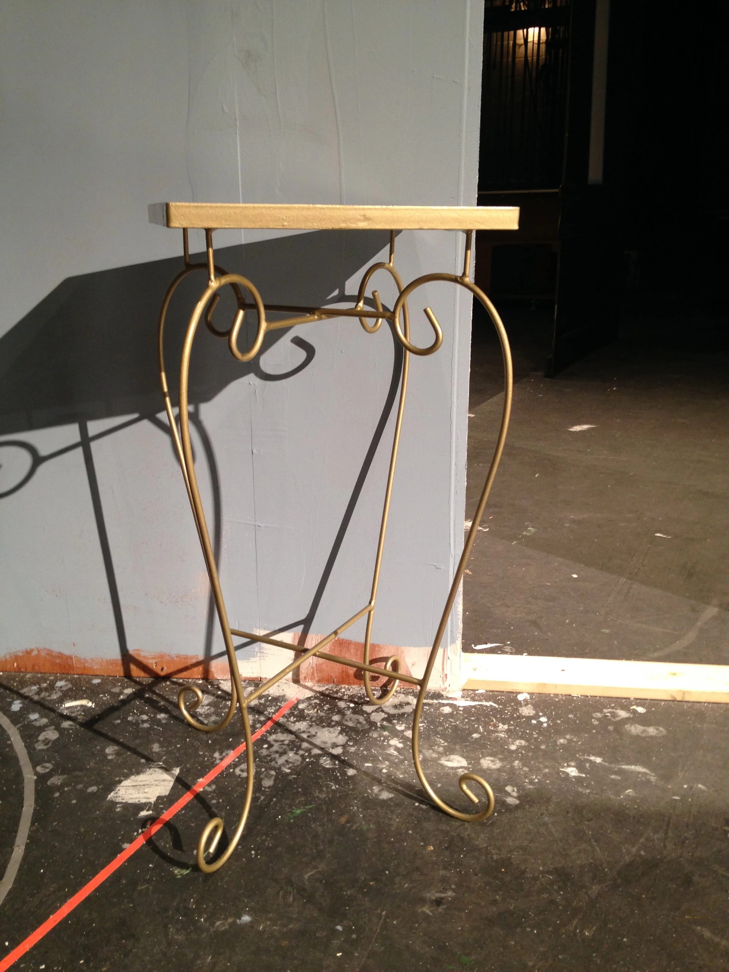 Gold painted table for water container.