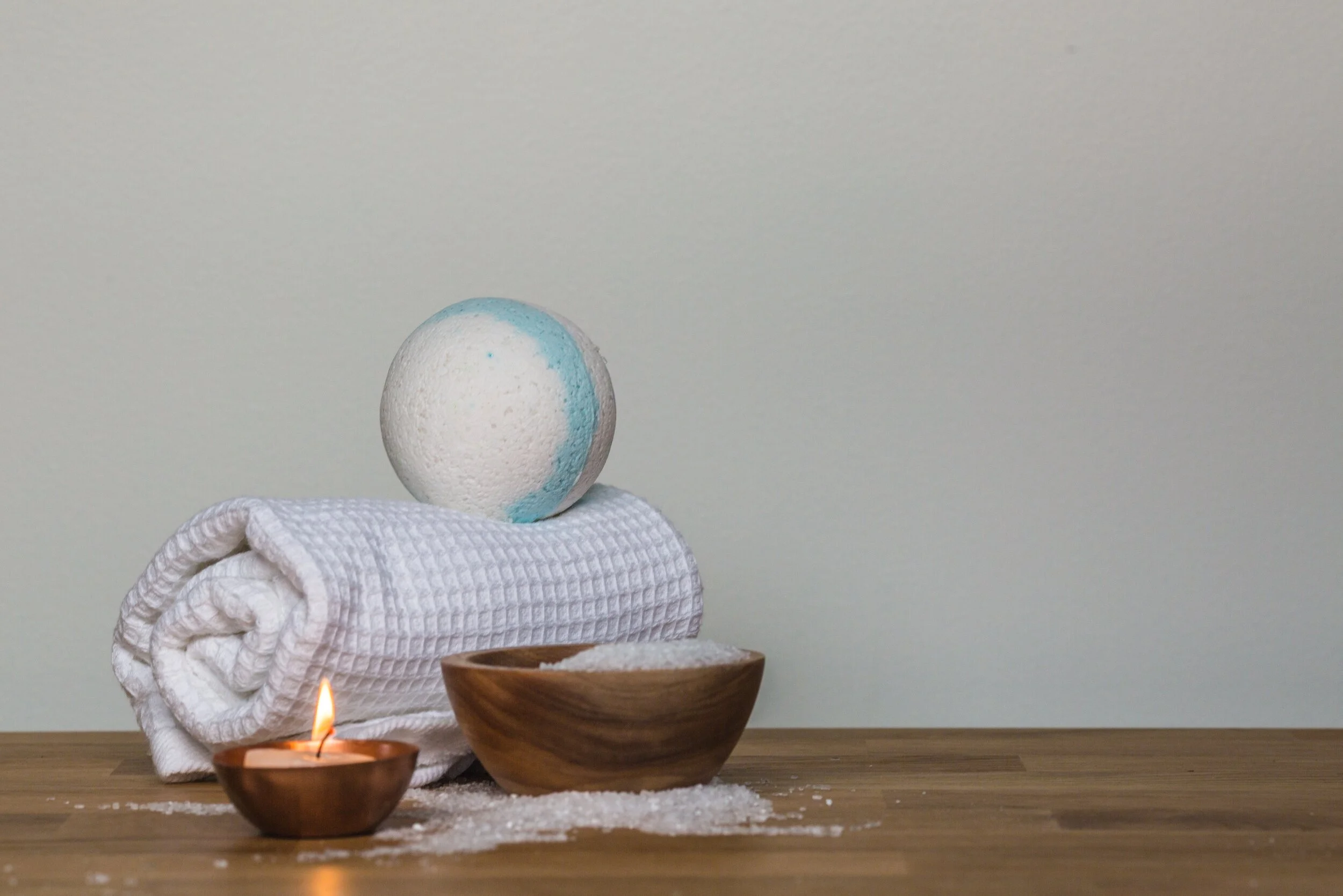 photo-of-towel-and-bath-bomb-near-candle-374071.jpg