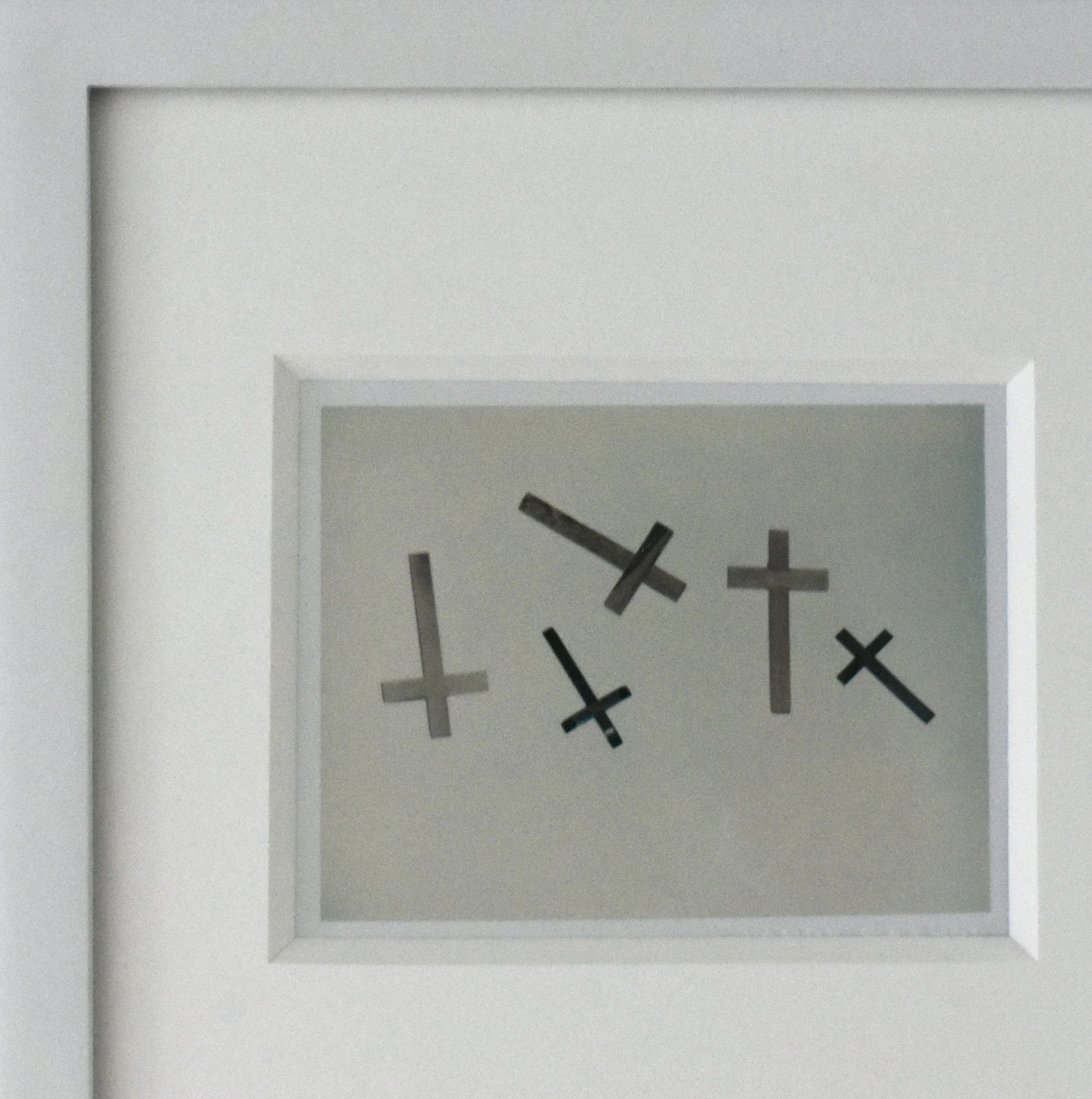 An upper left detail close-up of one of Andy Warhol’s unique Polaroid prints, 'Crosses', shown here framed.