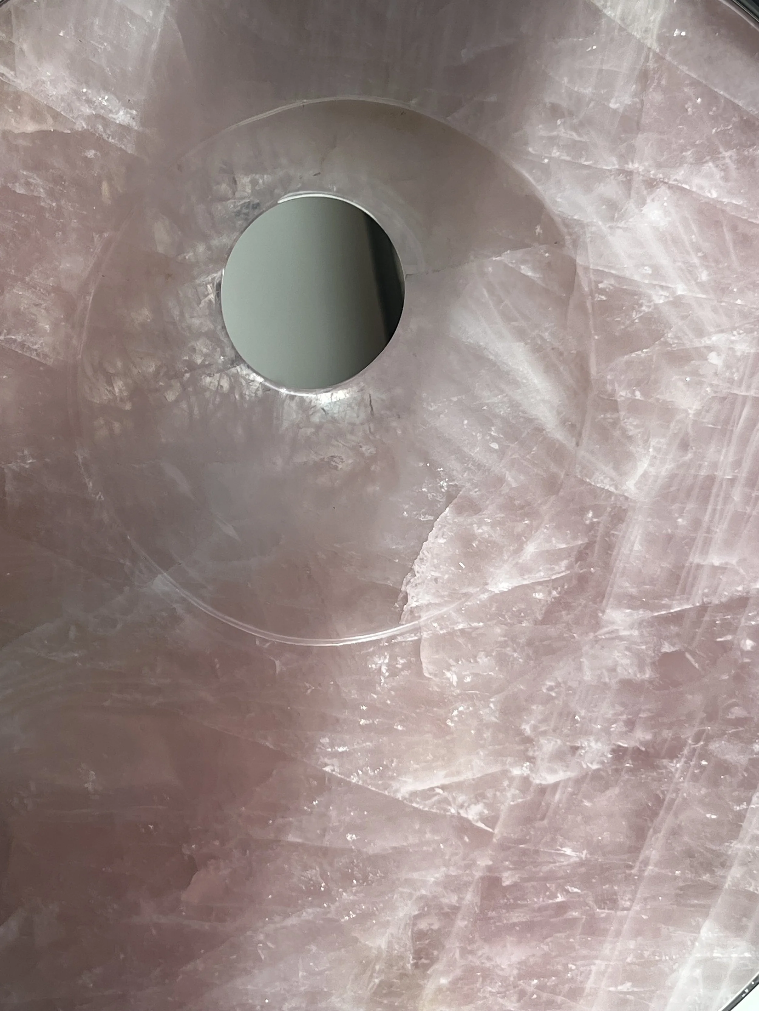 A detail image of Tarik Currimbhoy’s 316 Stainless steel and pink rock kinetic work, Surya. The pink rock element of the sculpture is shown here up close.