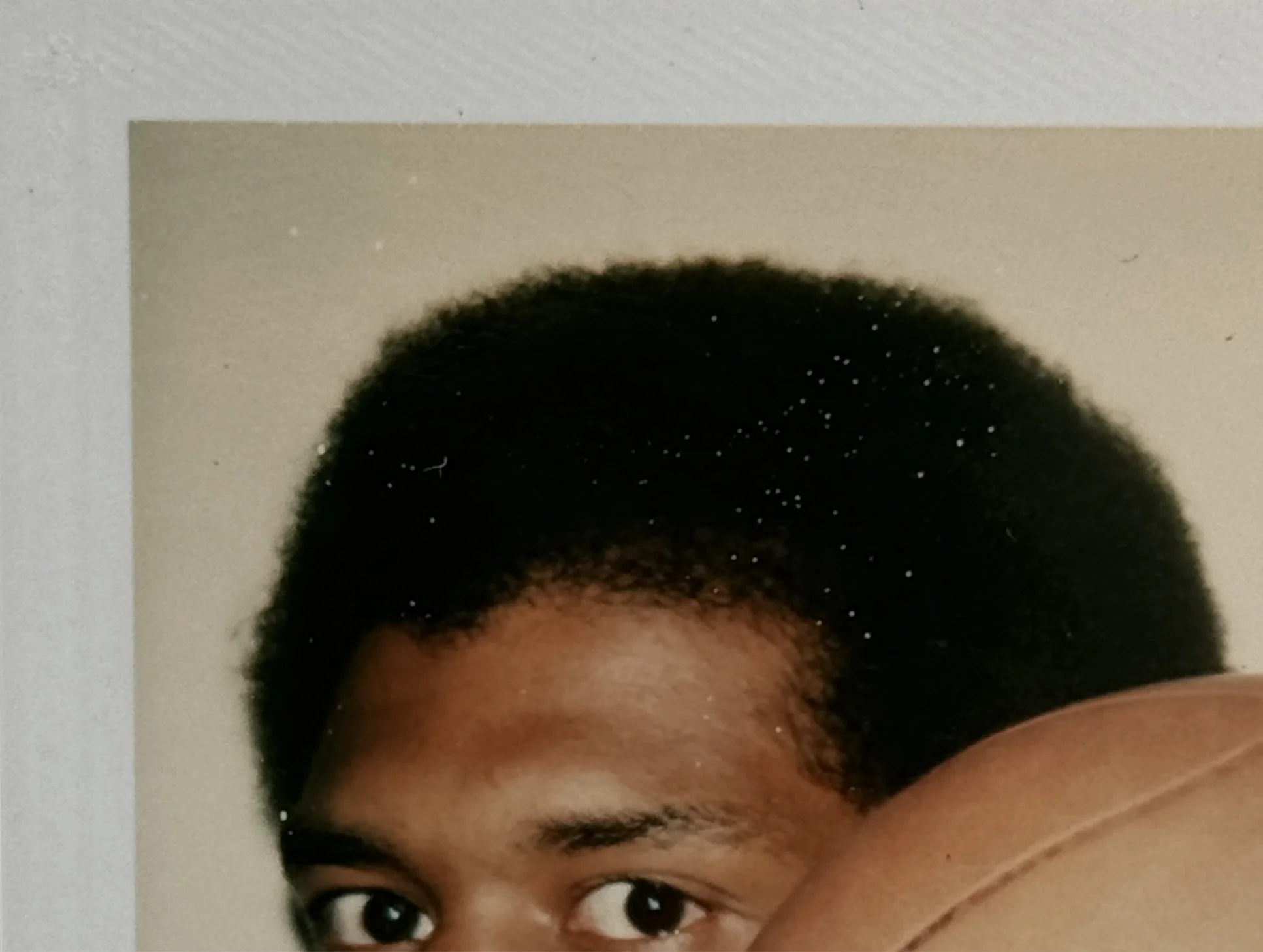 An upper left detail image of Andy Warhol’s unique Polaroid print, 'Kareem', shown here unframed.