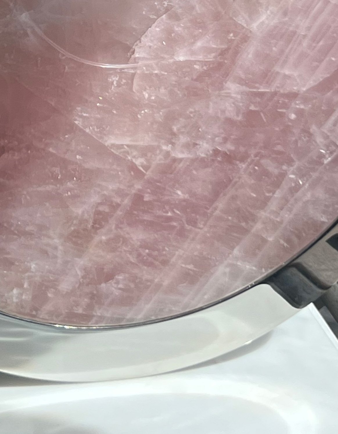 A detail image of Tarik Currimbhoy’s 316 Stainless steel and pink rock kinetic work, Surya. The work is shown here at its base.