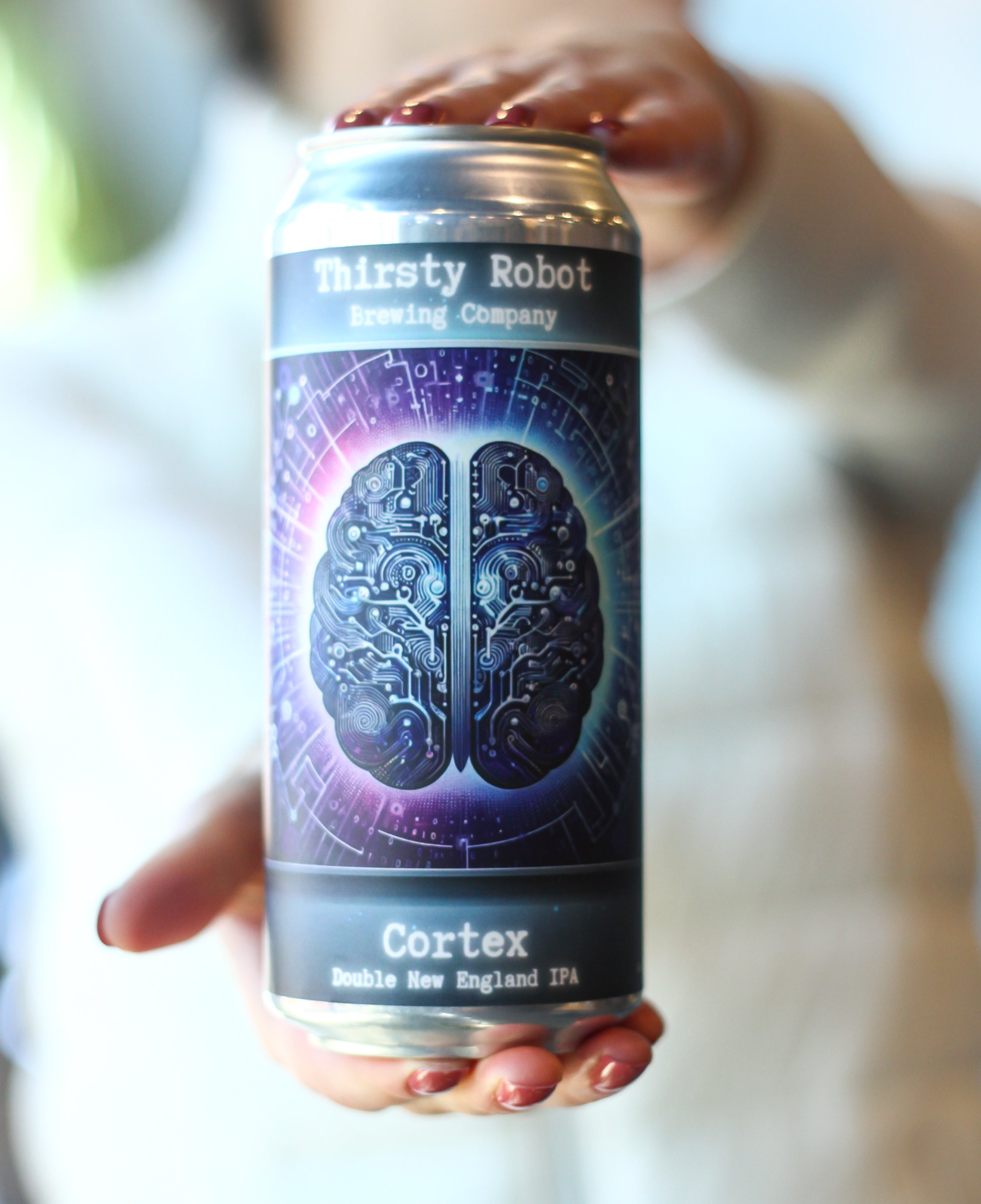 A hand holding a can of Cortex Double New England IPA craft beer with a digital brain logo and circuitry design.