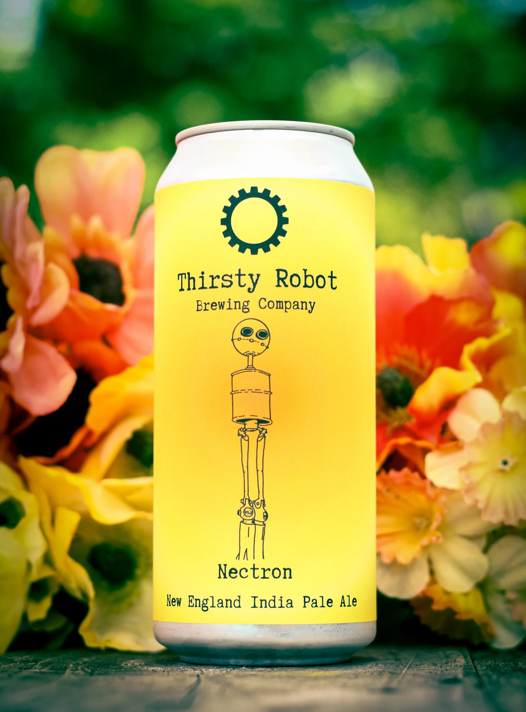 Can of Thirsty Robot Brewing Company Nectron New England India Pale Ale with yellow label featuring a robot illustration, displayed outdoors with colorful flowers in the background.