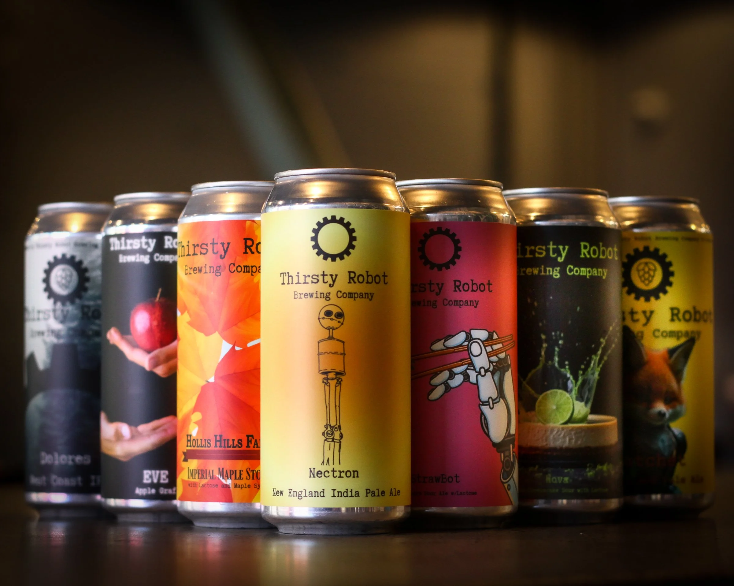A lineup of cans from Thirsty Robot Brewing Company with colorful and themed labels, featuring illustrations of robots, fruit, and animals.
