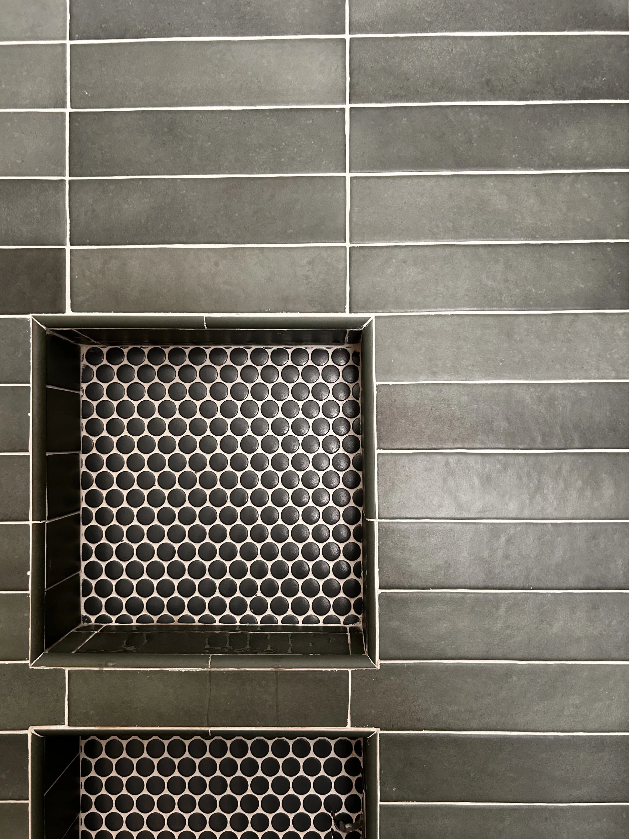 Sage green subway tile shower, dark grey penny tile niche