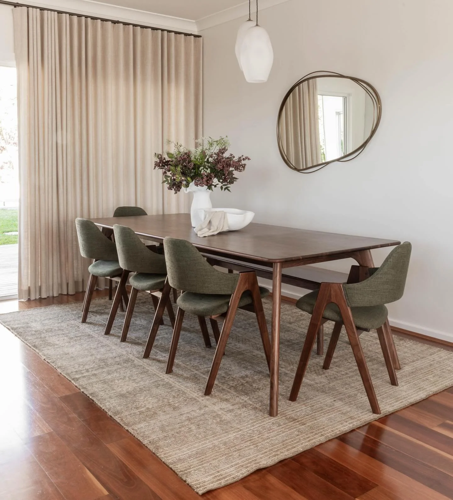 A beautiful seamless home where walnut and brass harmonise with the moss green dining chairs, hand blown pendants and textured linen curtains. Maintaining the mid century style while adding glimpses of contemporary and coastal to suit its surrounding