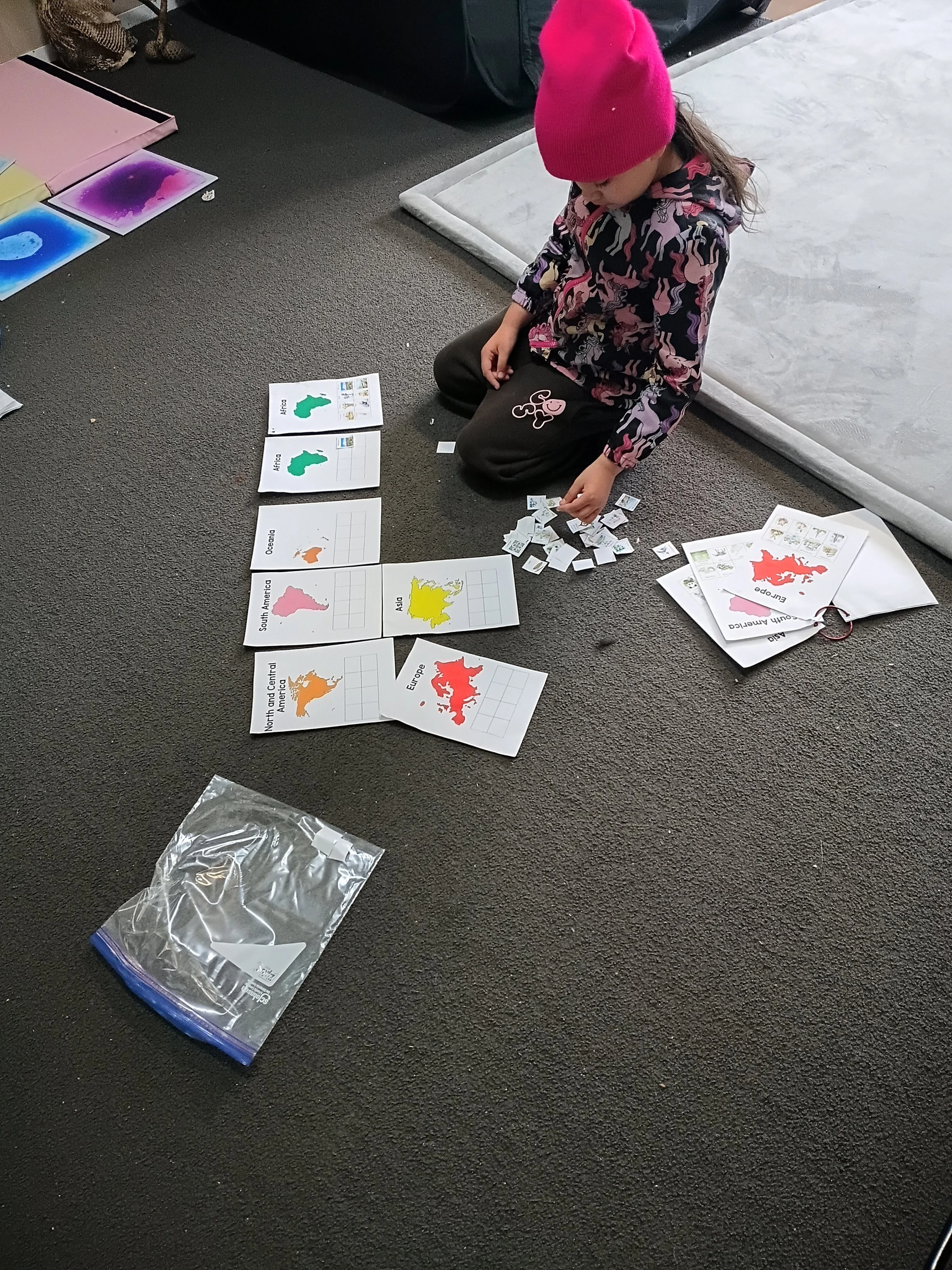 Child independently working with geography learning cards