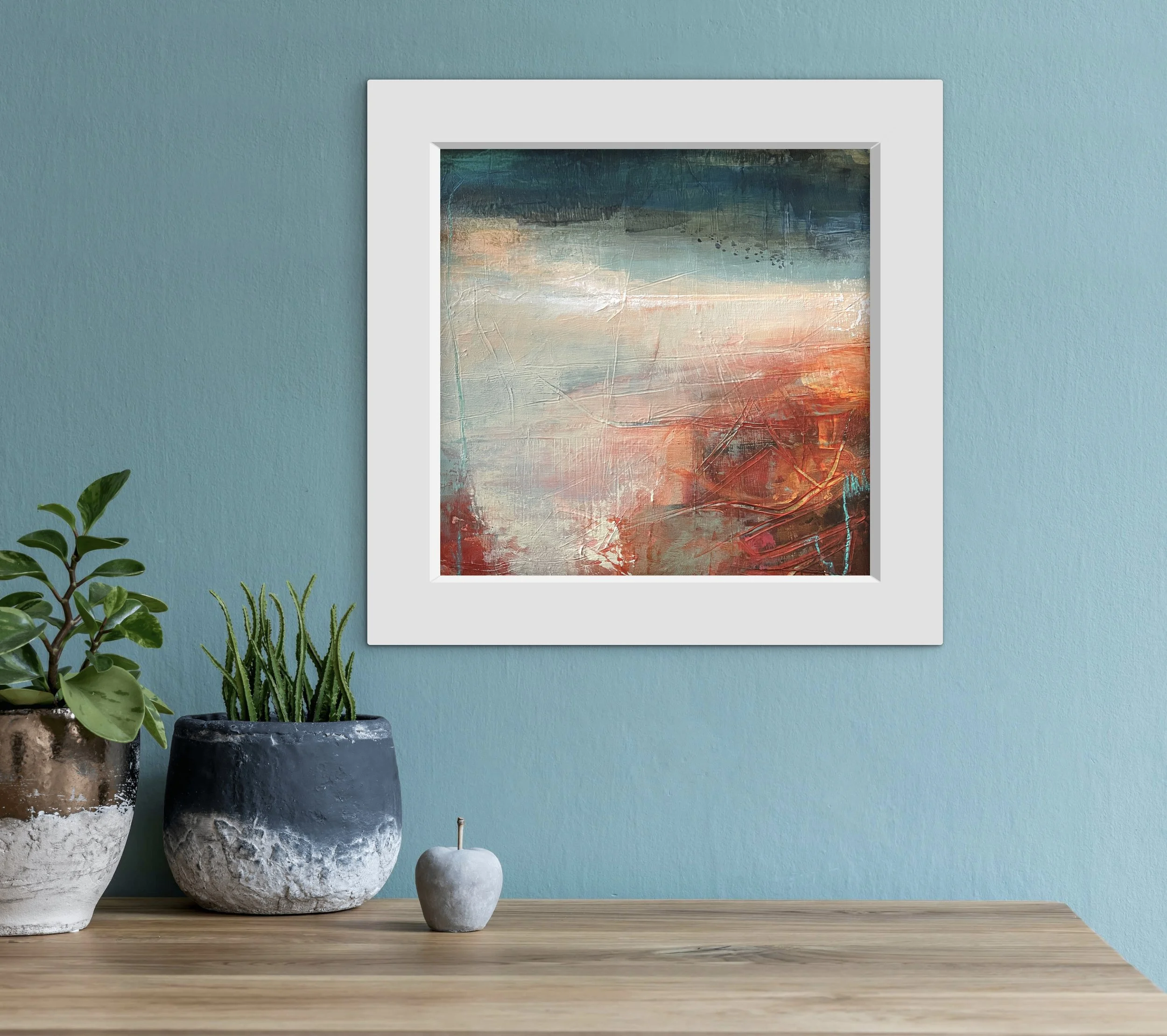 Small orange and blue abstract landscape hanging on a blue wall