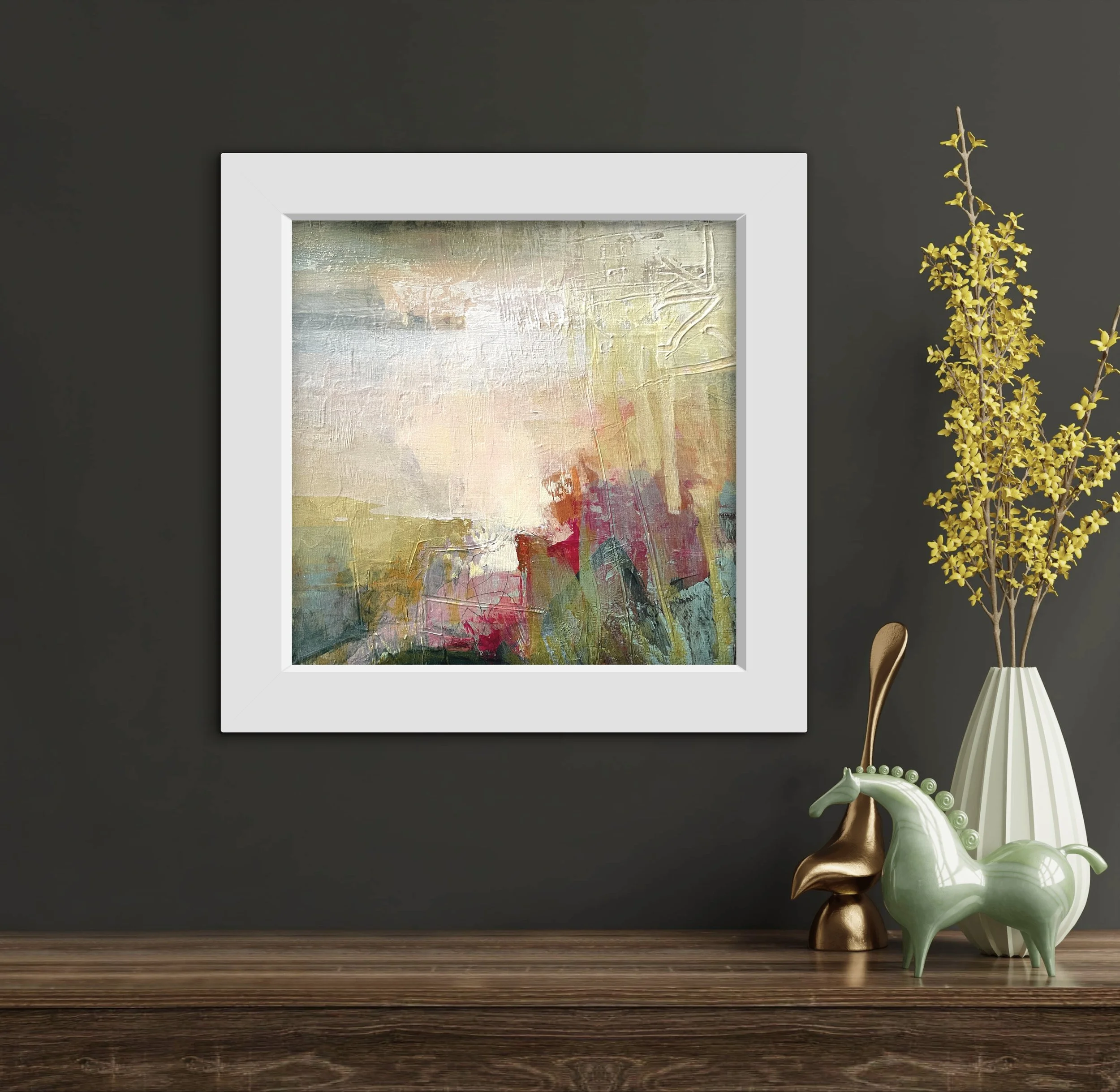 small pink and yellow abstract landscape hung on a dark wall