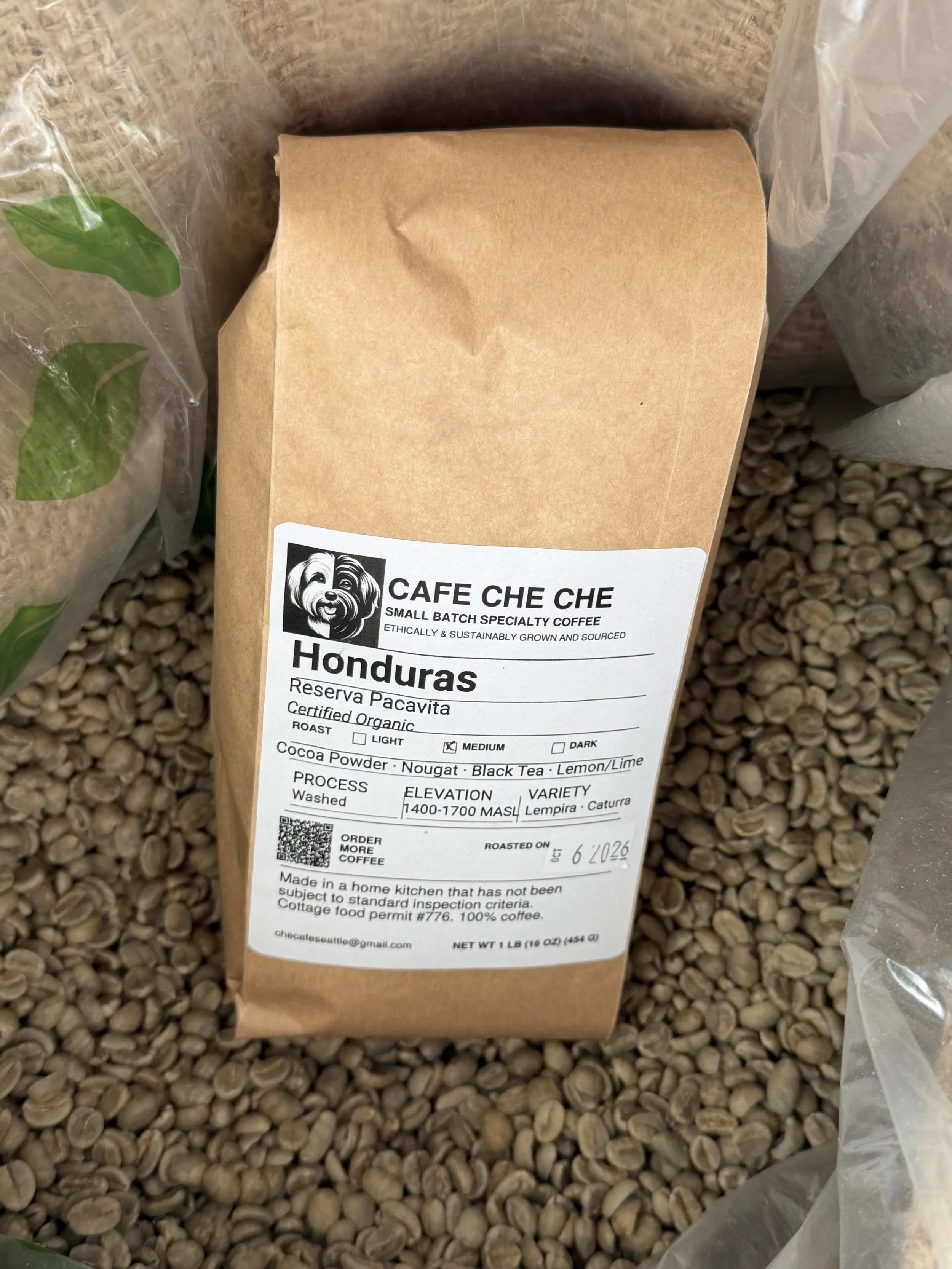 Cafe Che Che Honduras coffee bag resting on green coffee beans