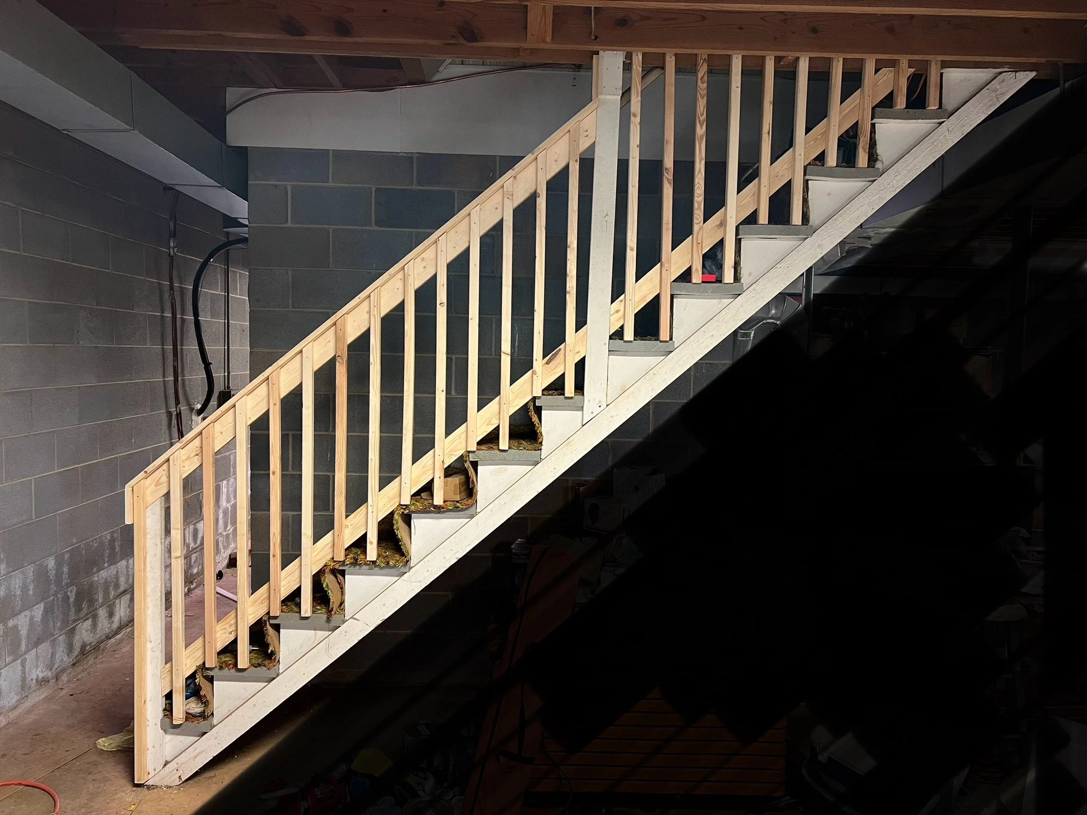 Basement stair rail addition to protect kids from falling. Picture redacted for customer privacy.