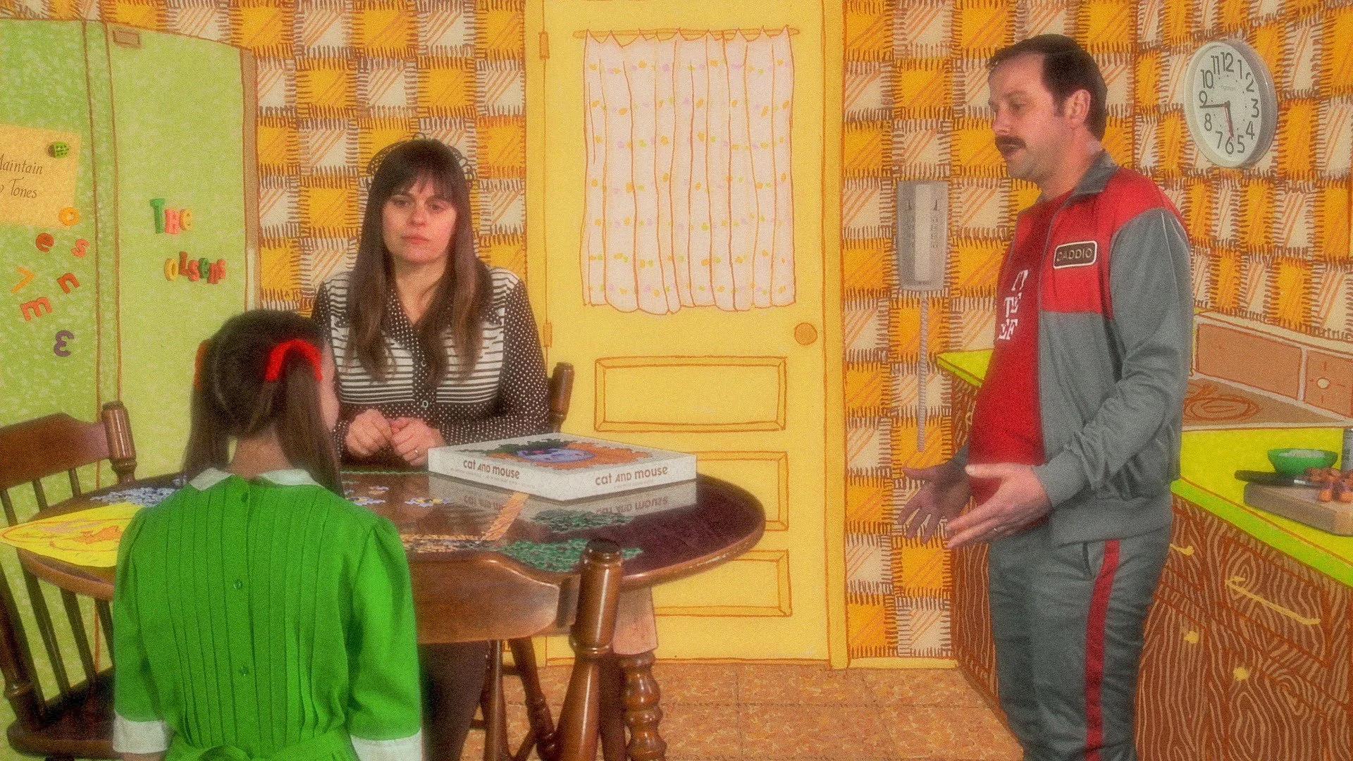 A family argues in a 1980s kitchen.