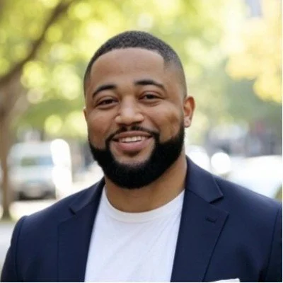 Image of Michael Baldwin in a white t-shirt and navy jacket