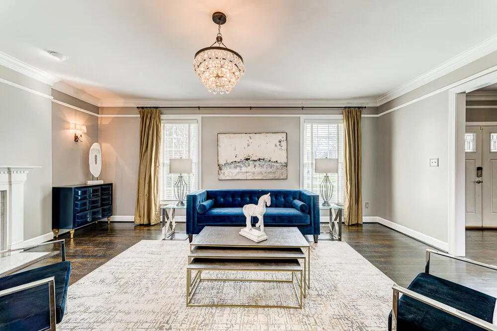 Living room with navy sofa and chandelier