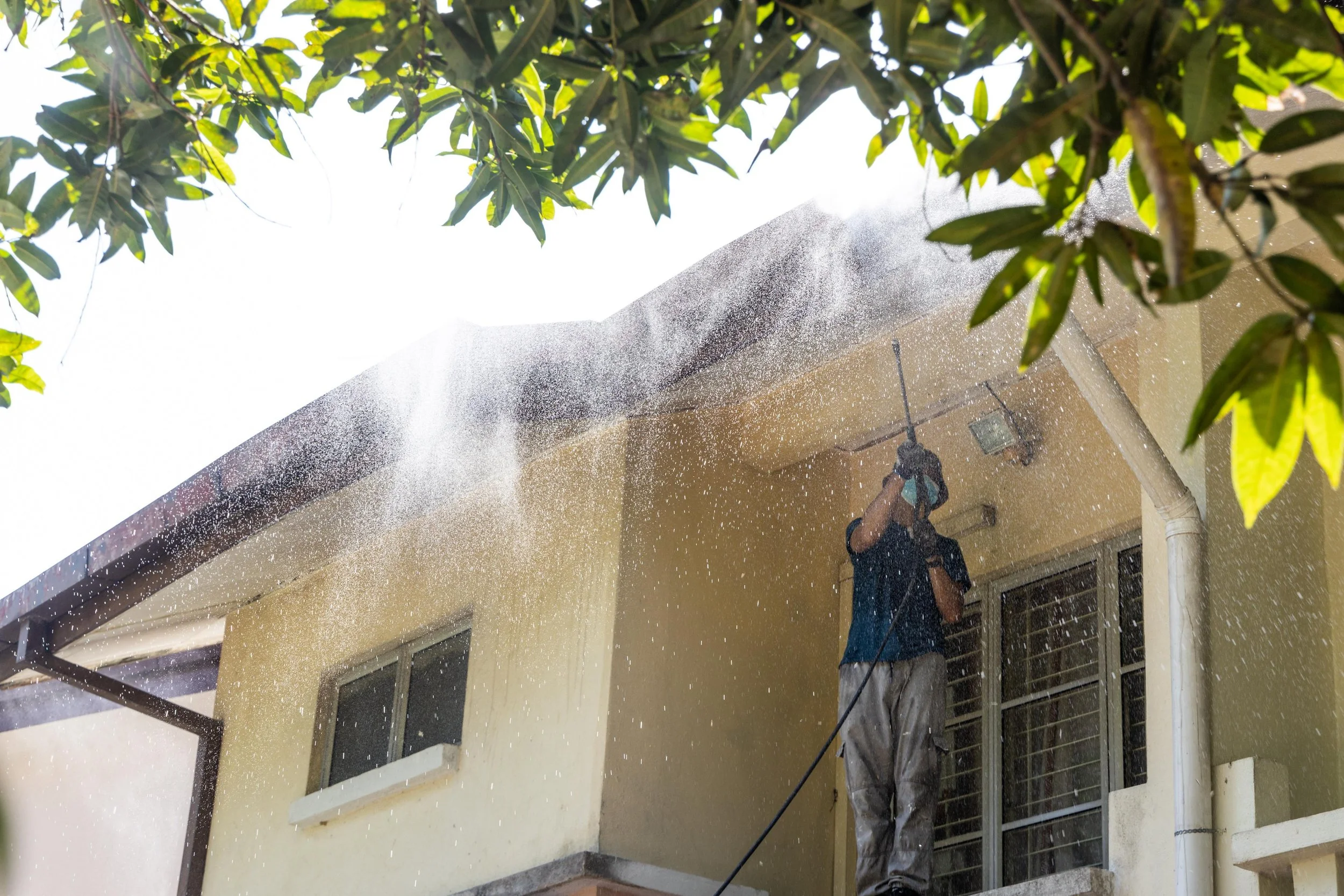 A man figures out the spring is the best time to power wash your house.