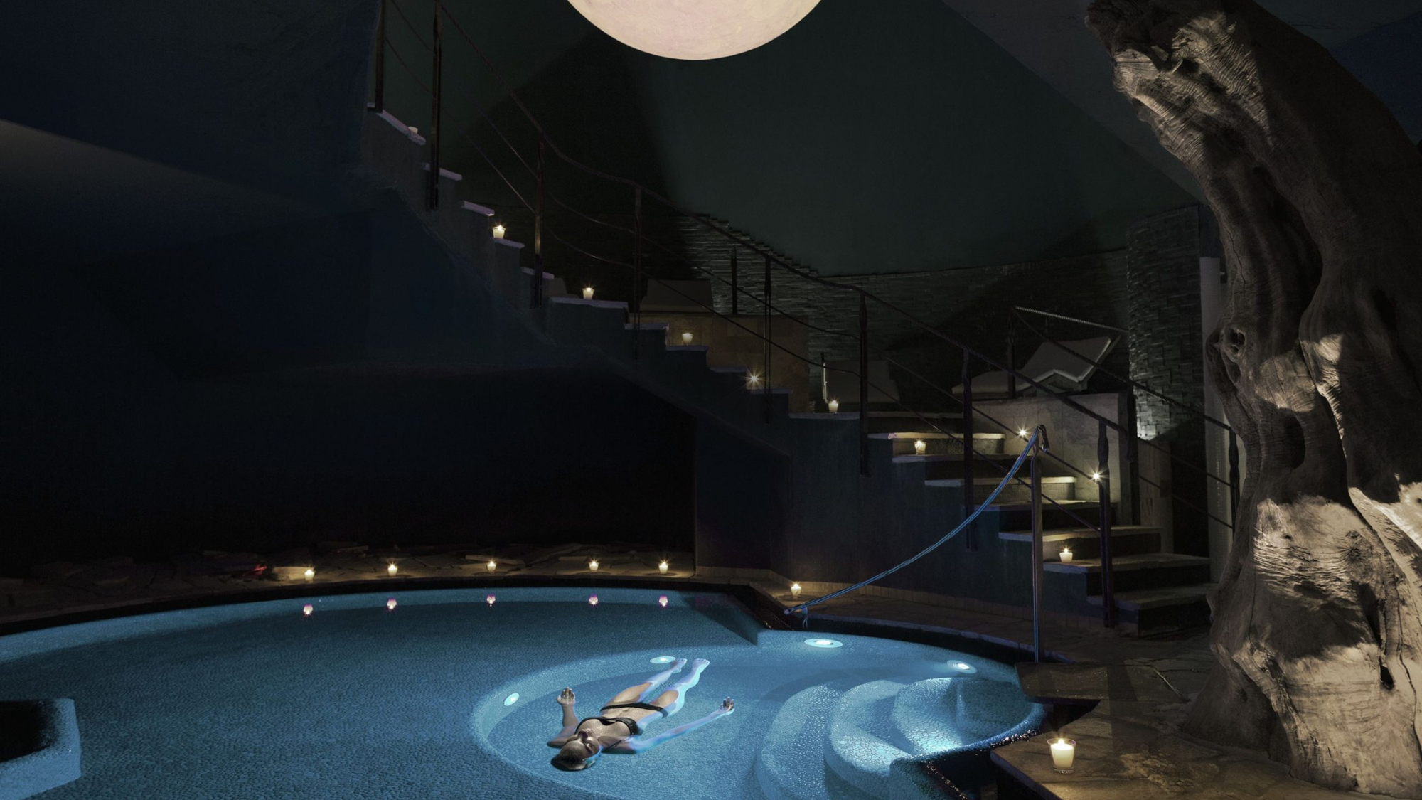 Huffman Travel - Image of Lefay Resort & SPA Lago di Garda woman floating in pool at night