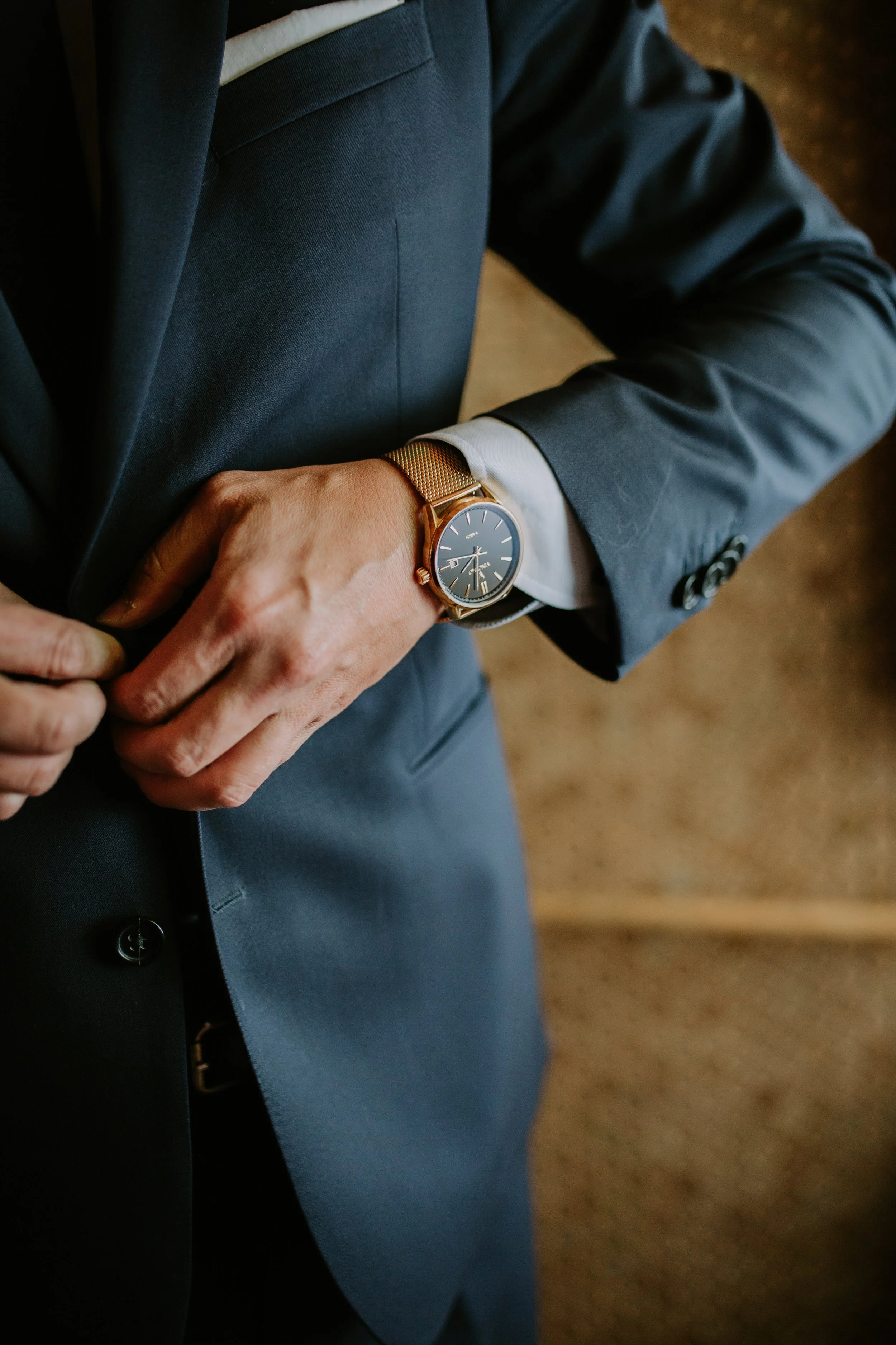 Person wearing a blue suit and watch