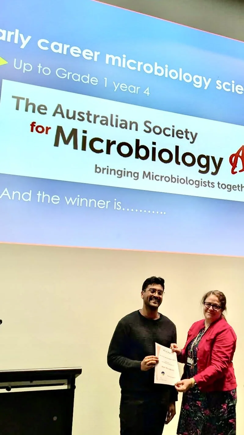 NFTH - Oct 2026. Host and Victorian Branch Committee member Teresa Abajo presenting Ryan Weerakkody with a certificate for claiming the Early Career Scientist prize.