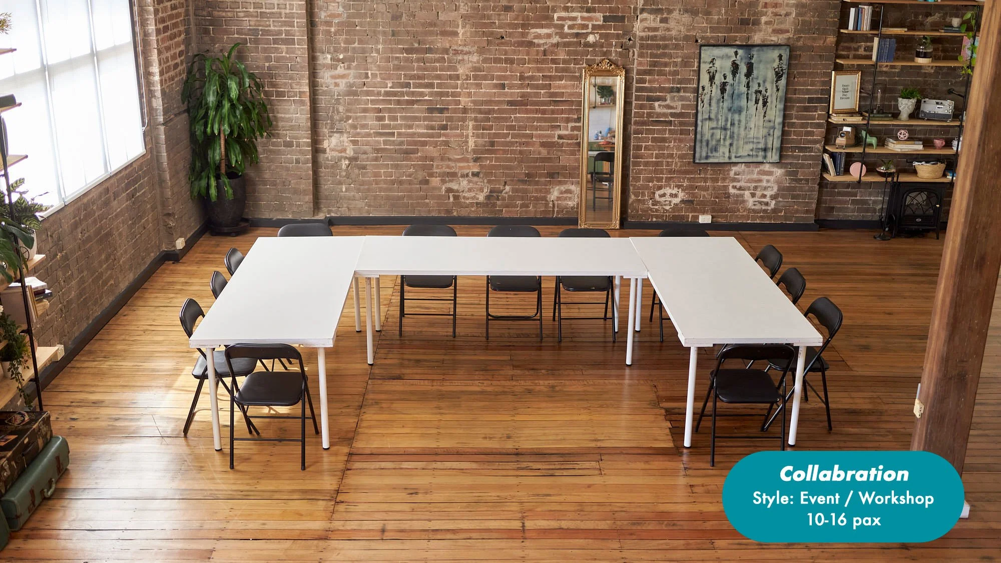 Loft-style workshop space with white tables, folding chairs, exposed brick walls, plants, bookshelves, and a mirror; seating for 10–16 people at the Dale Studio in Chippendale. 