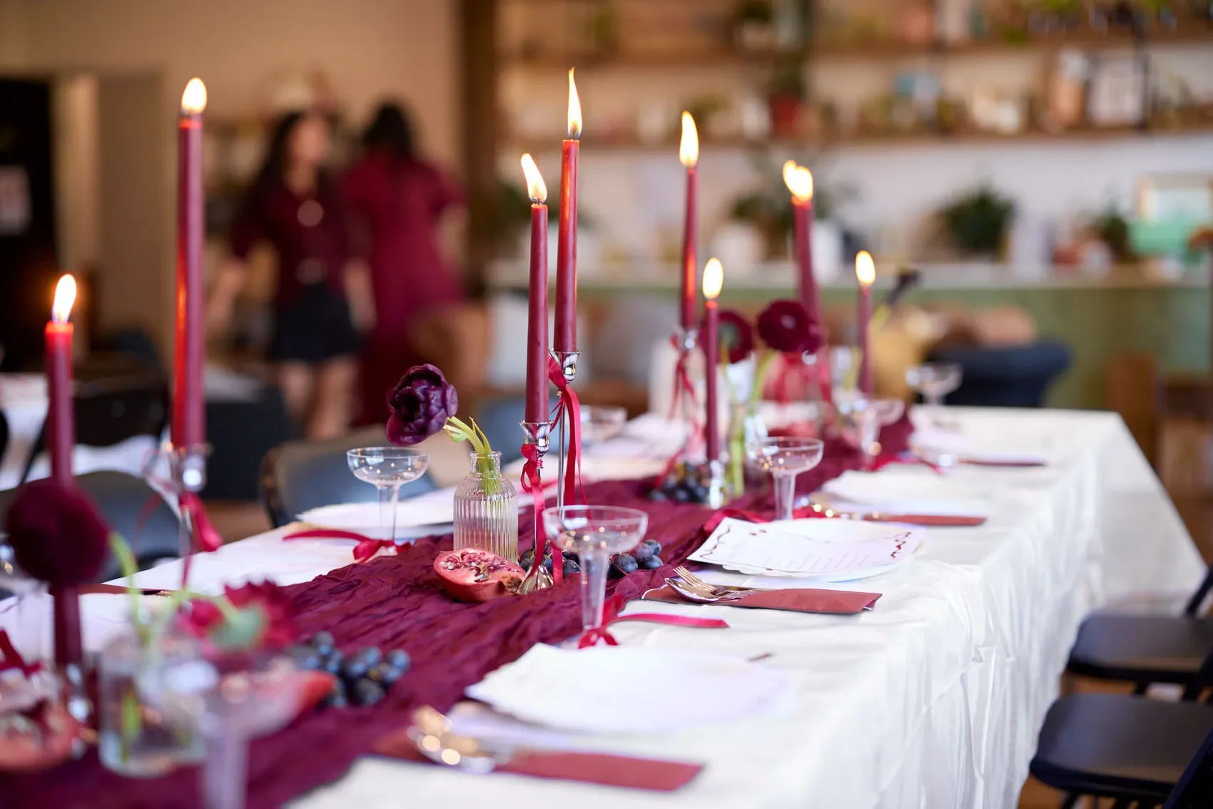 Elegant banquet table set with burgundy candles, flowers, glassware, and white place settings at the Dale Studio in Chippendale. 