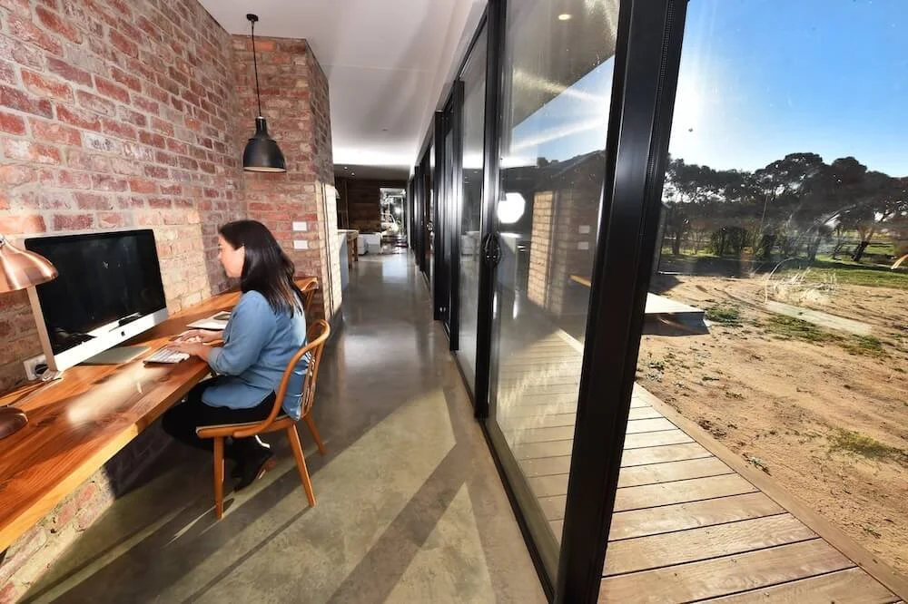 Lisa sits in the Booken House office nook, answering emails